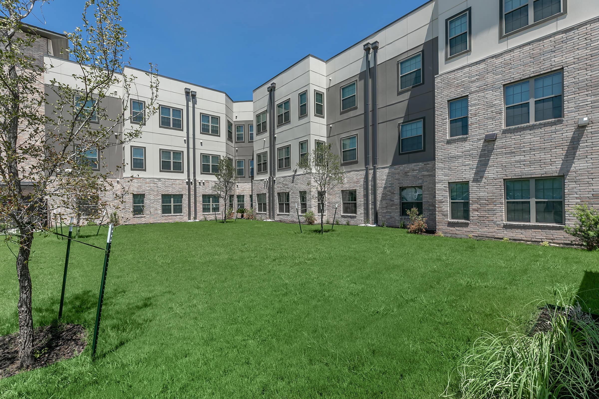 a large green field in front of a building