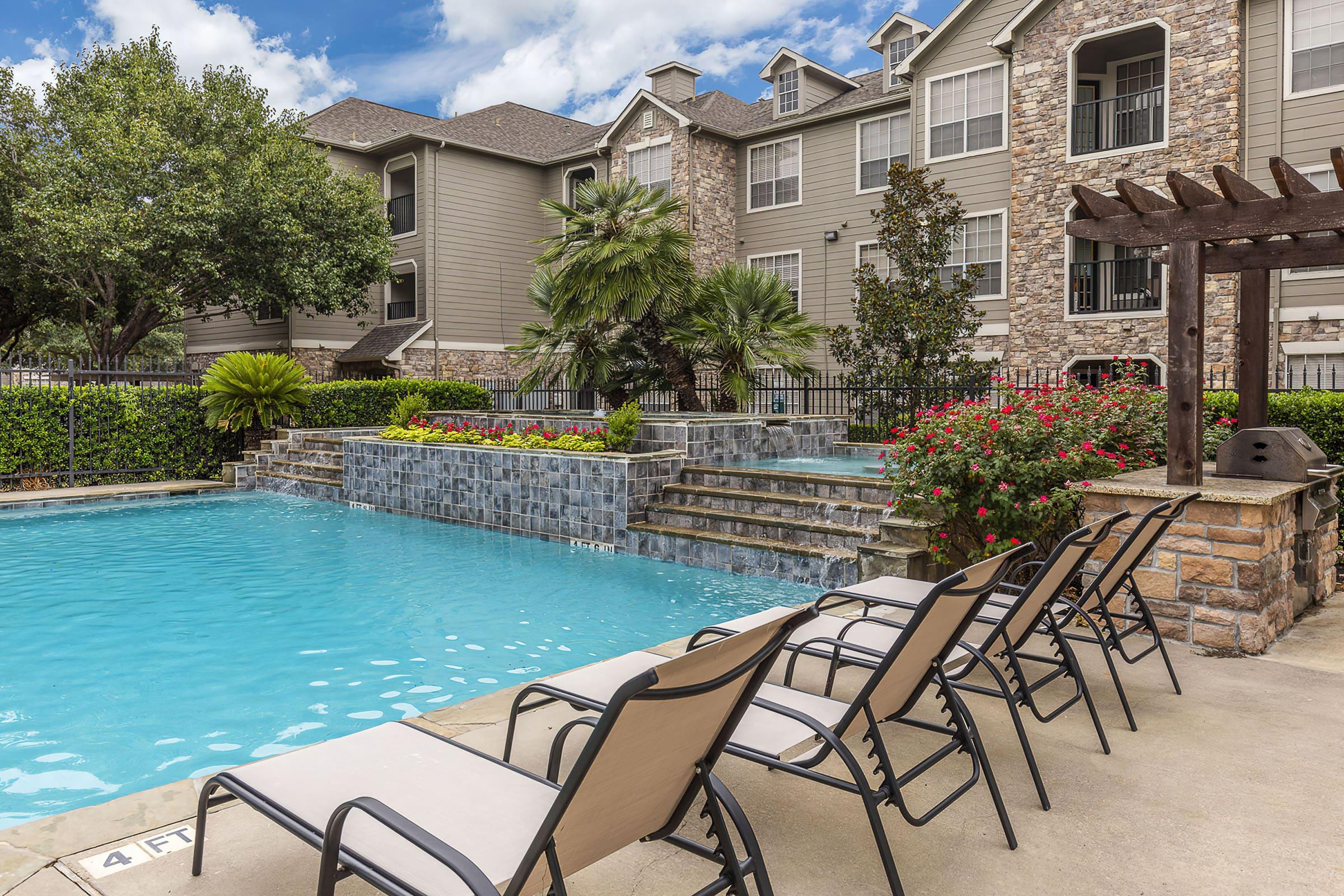 a row of lawn chairs sitting next to a pool of water