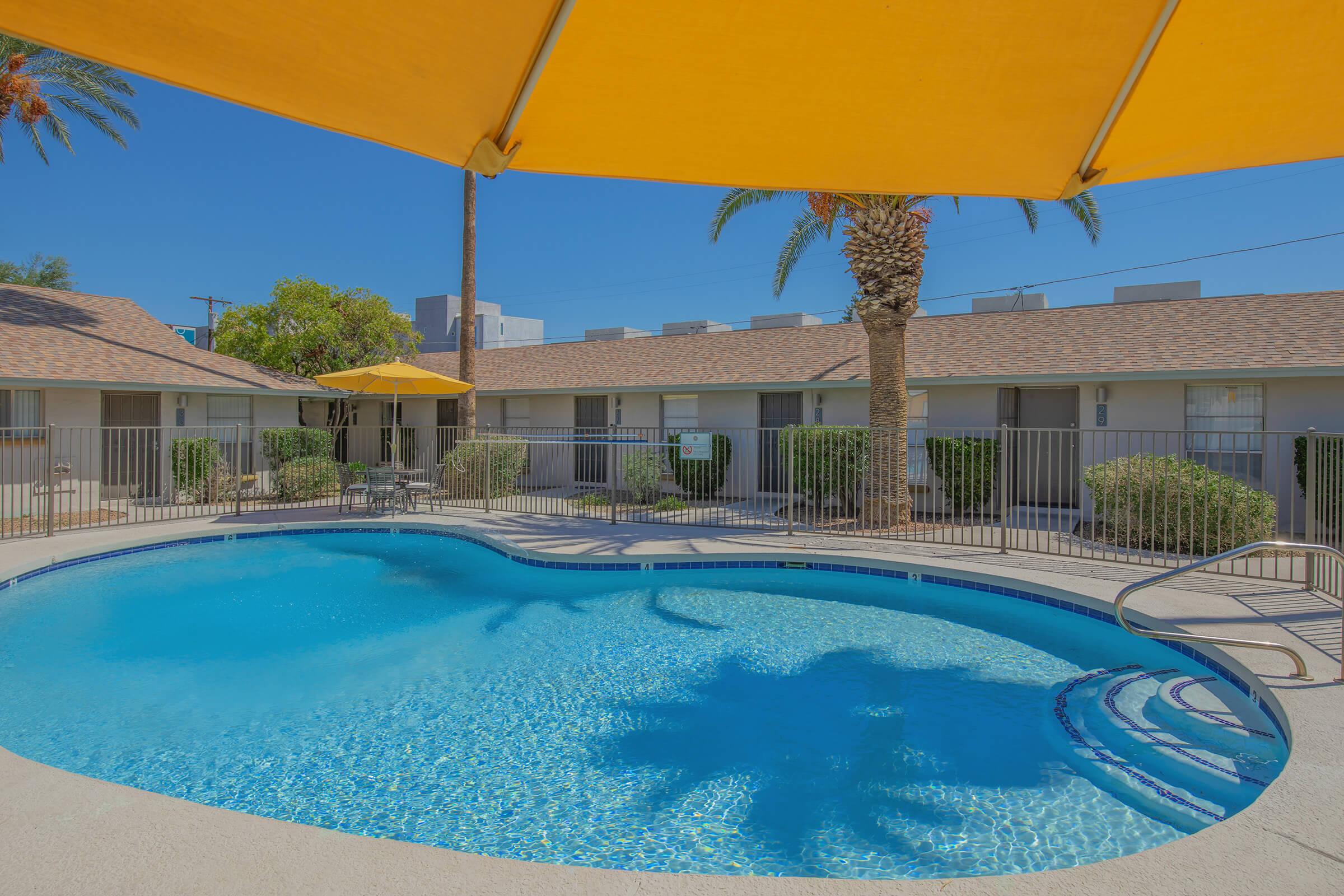 a blue umbrella next to a swimming pool