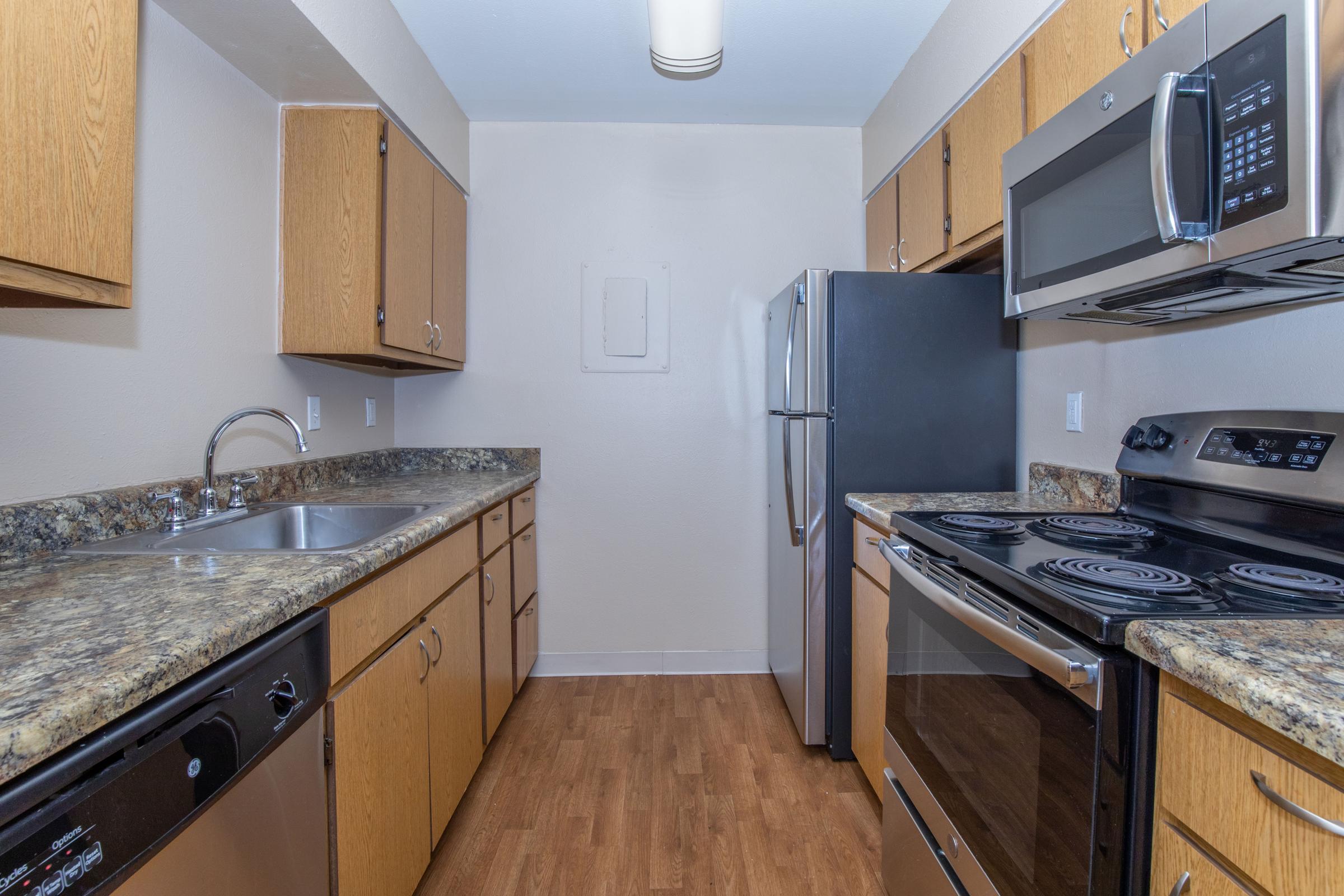 a kitchen with stainless steel appliances and wooden cabinets