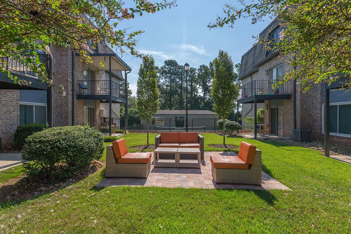 a group of lawn chairs sitting on a bench in front of a house