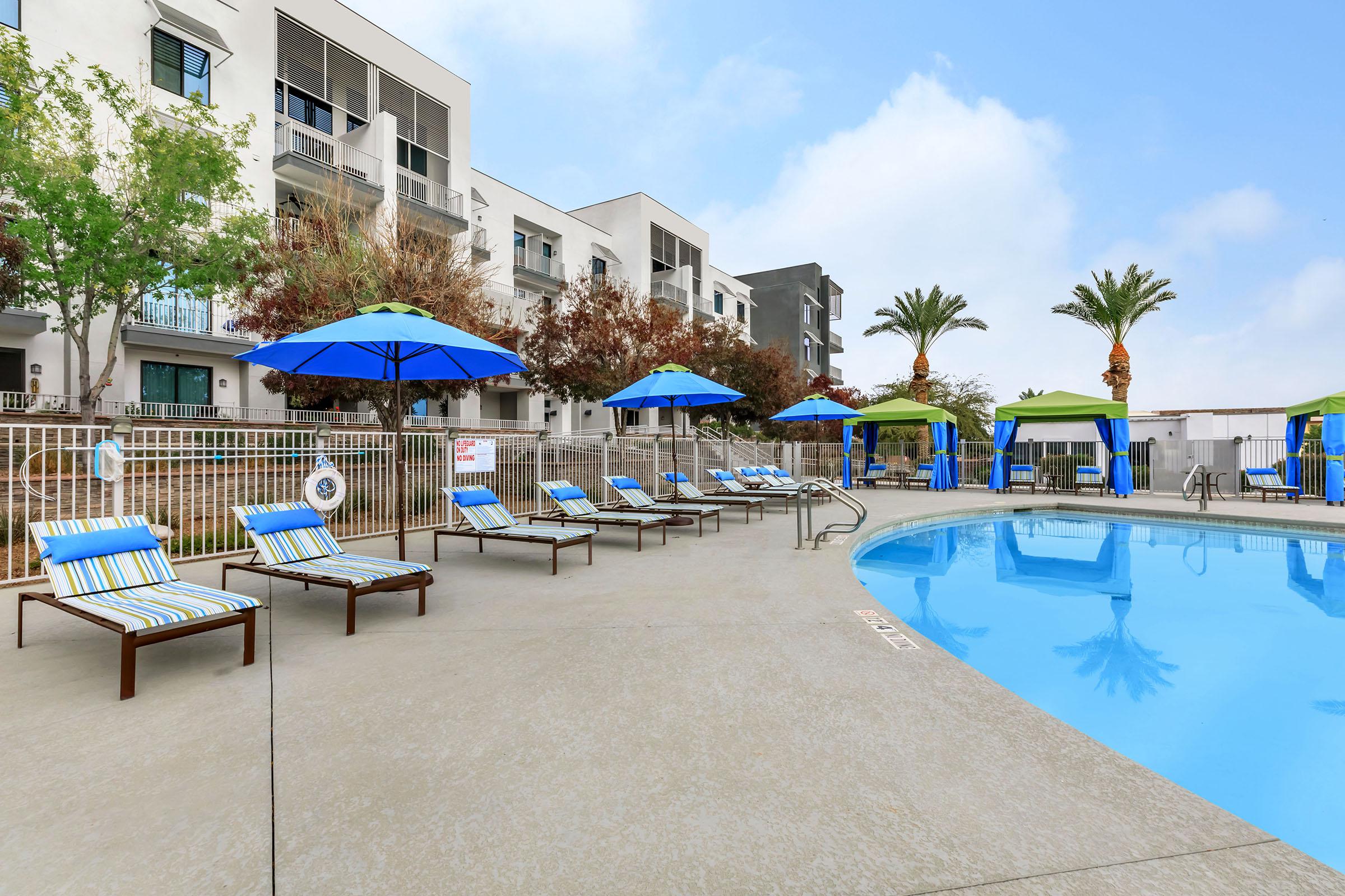 a group of lawn chairs sitting on top of a blue pool of water