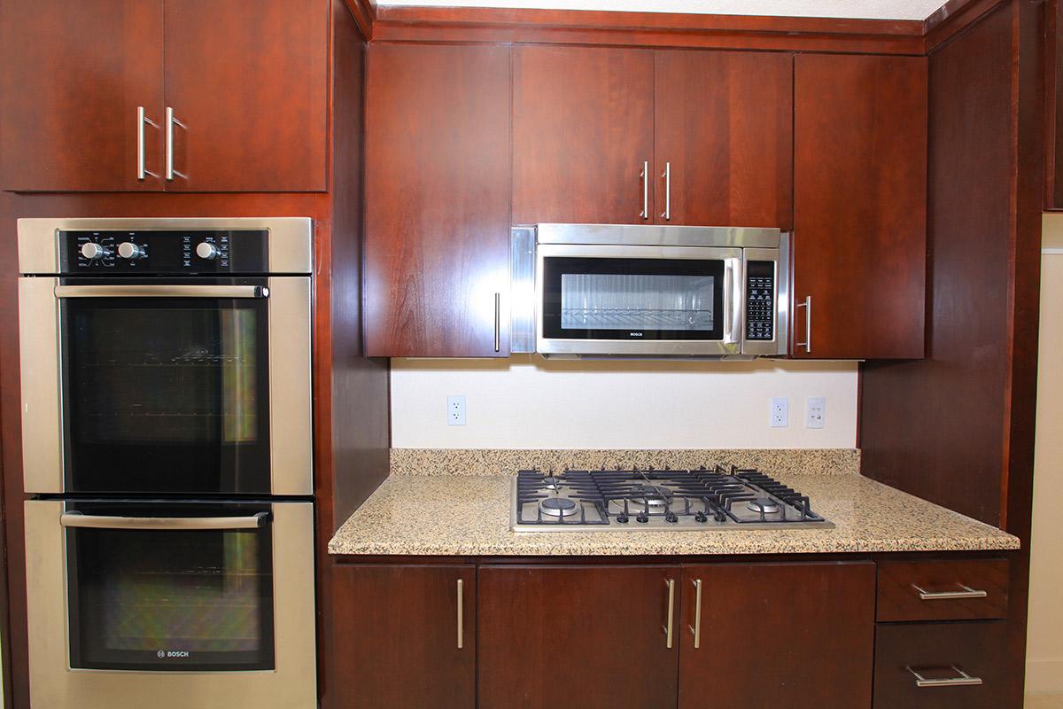 a stove top oven sitting inside of a kitchen with stainless steel appliances
