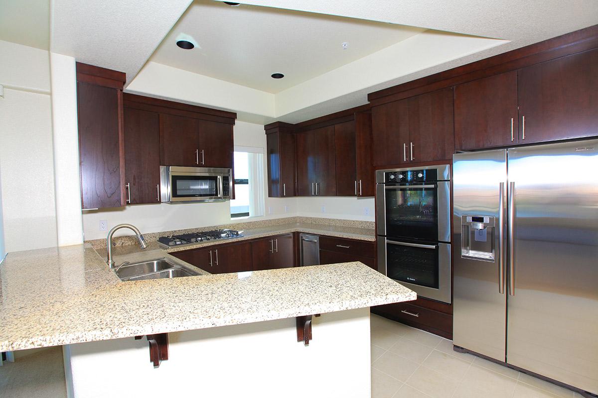 a modern kitchen with stainless steel appliances and wooden cabinets