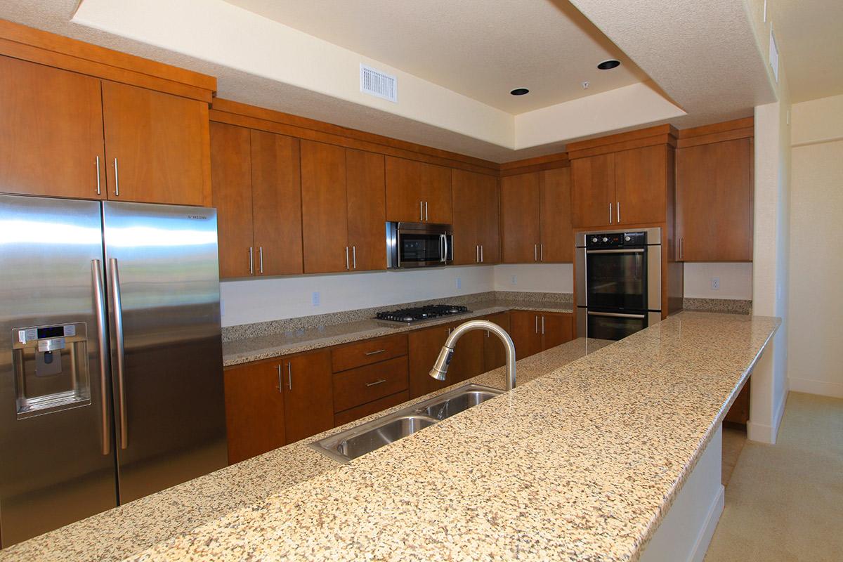 a modern kitchen with stainless steel appliances and wooden cabinets