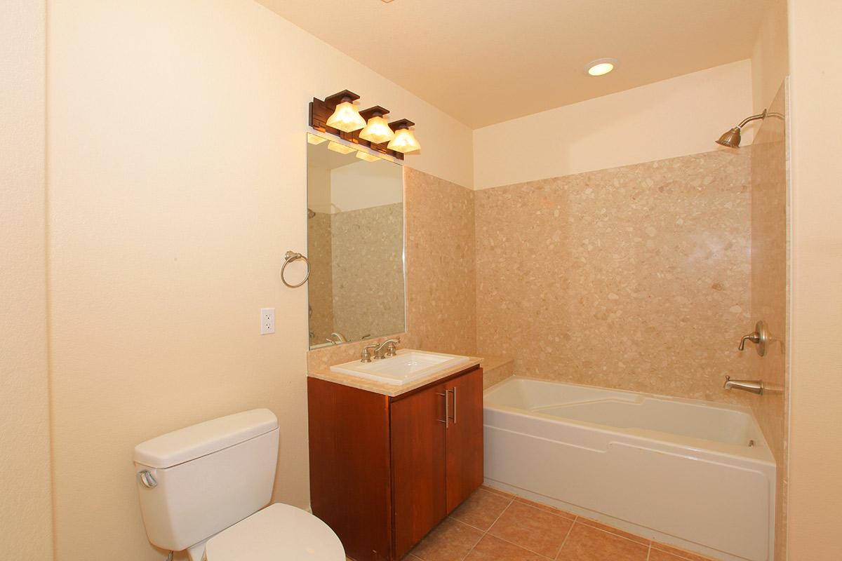 a white sink sitting under a mirror