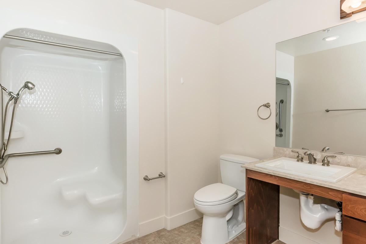 a white sink sitting under a mirror