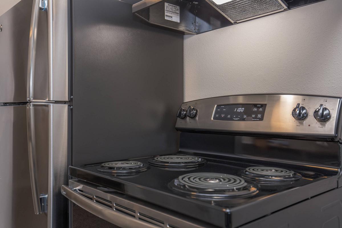 a black stove top oven sitting inside of a kitchen with stainless steel appliances