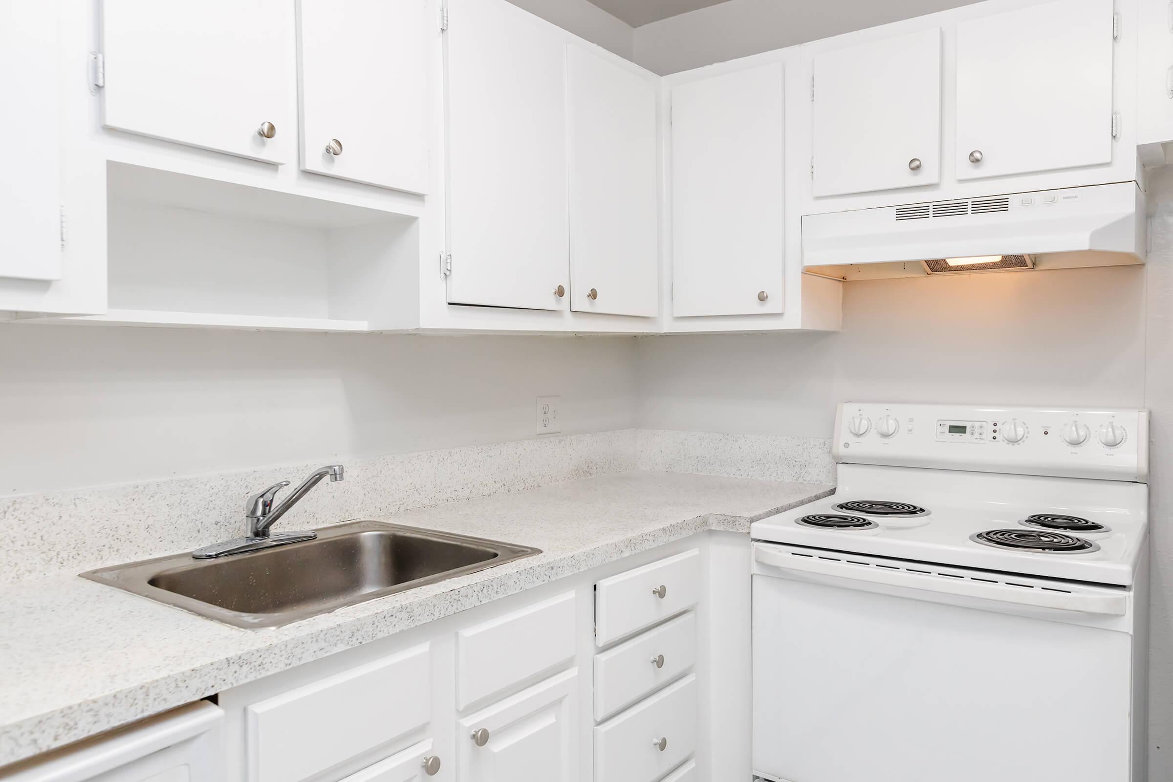 a stove top oven sitting inside of a kitchen