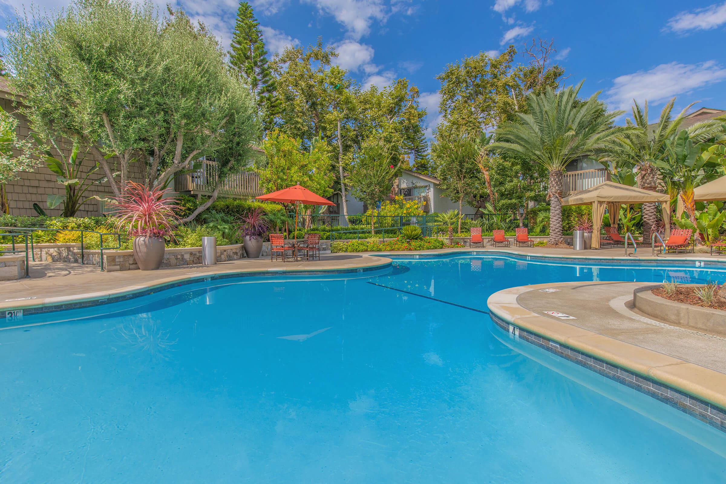 a community pool with green trees