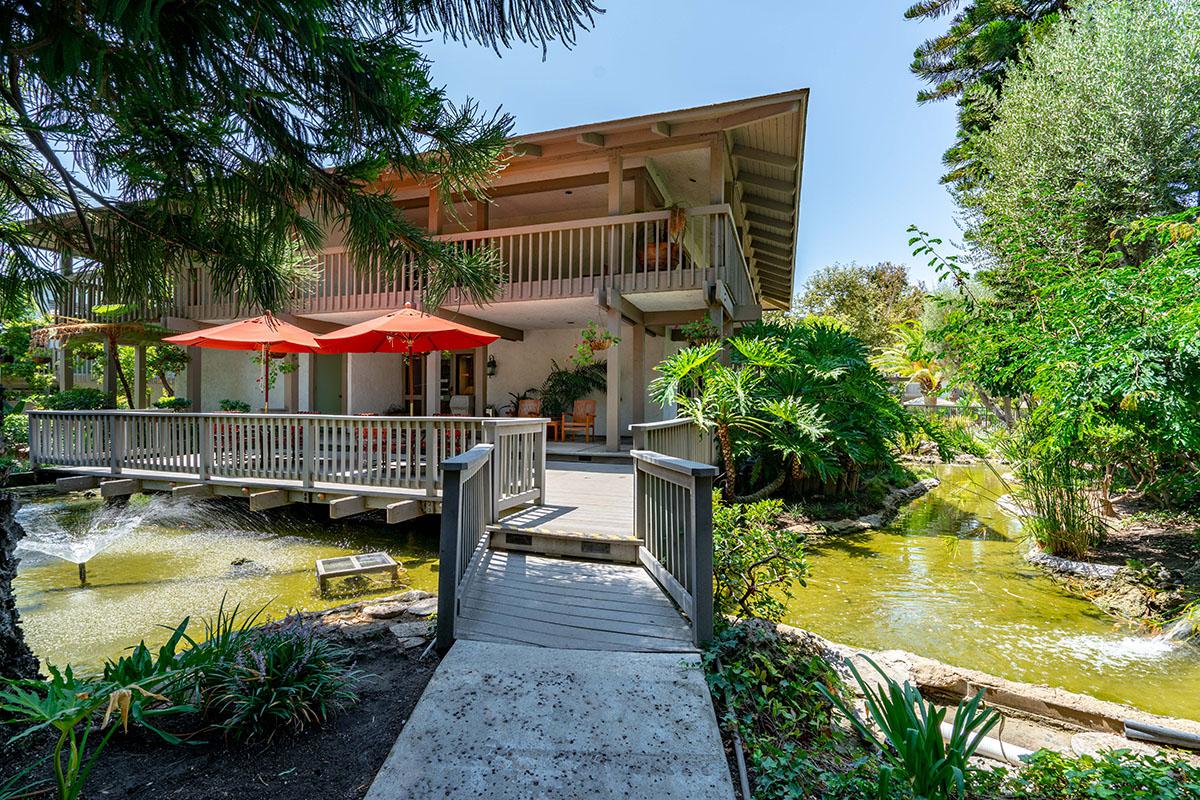 a house with bushes in front of a pool