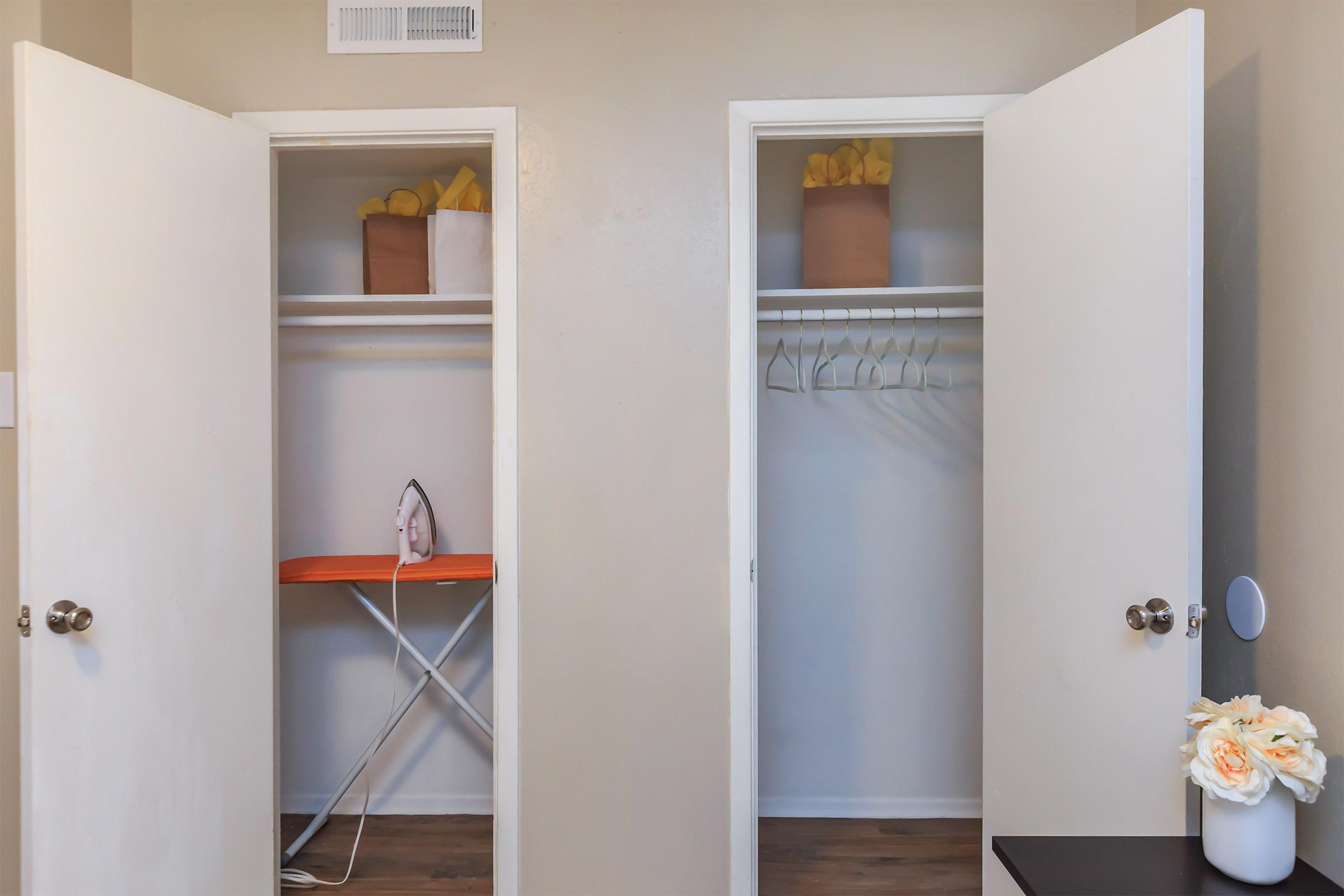 Two open closet doors with an iron