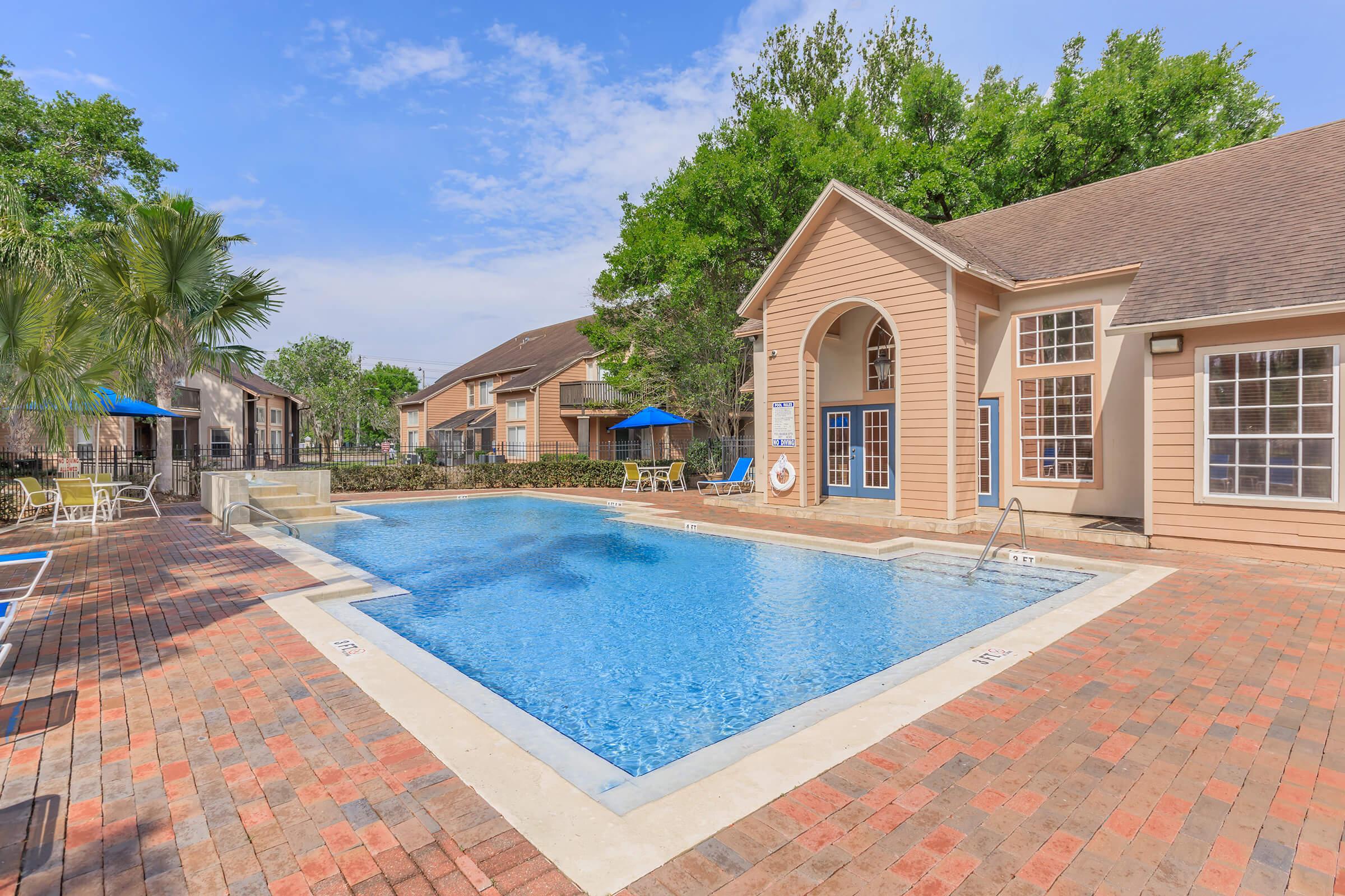 a large brick building with a pool in front of a house