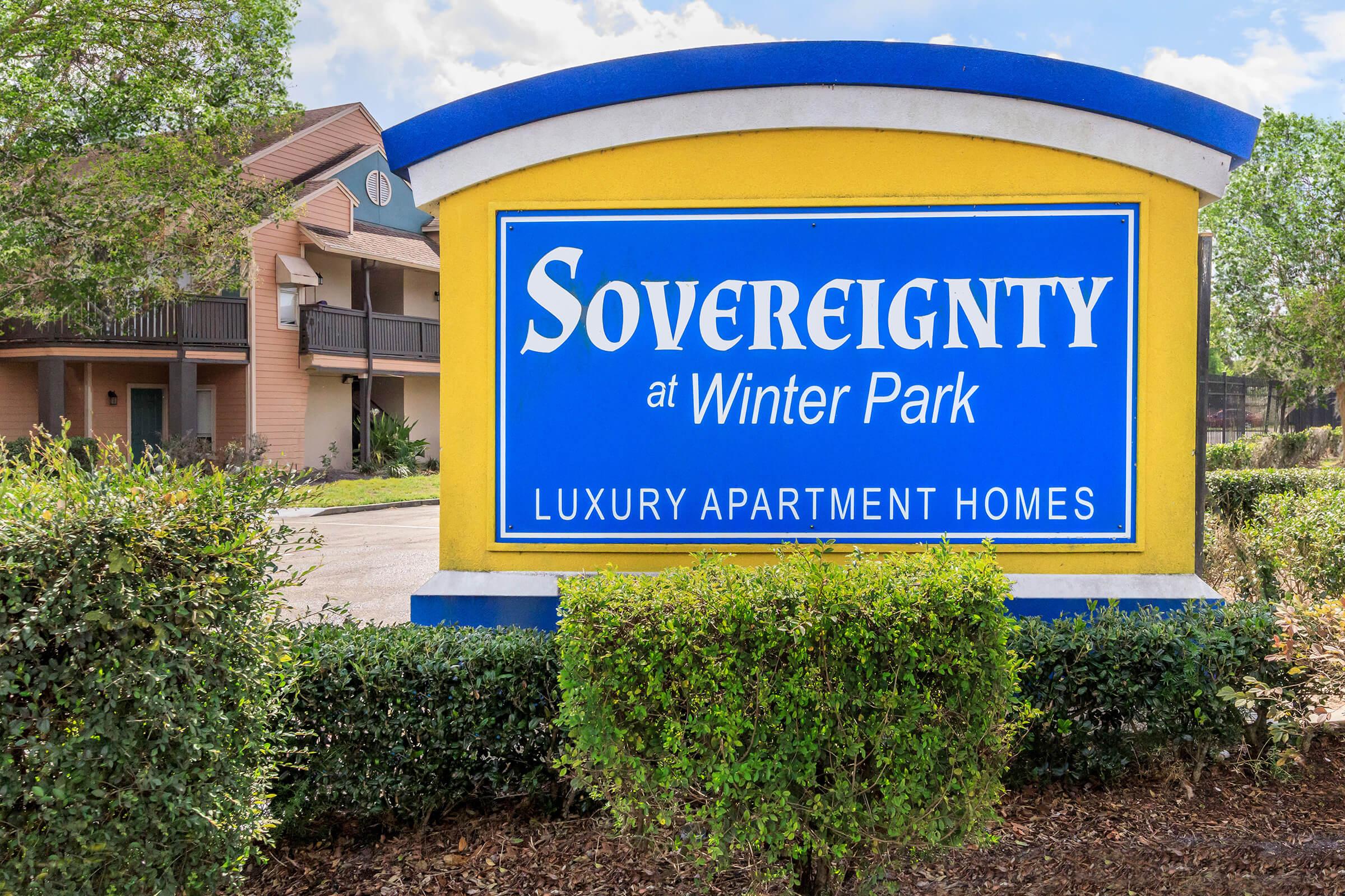 a blue sign in front of bushes