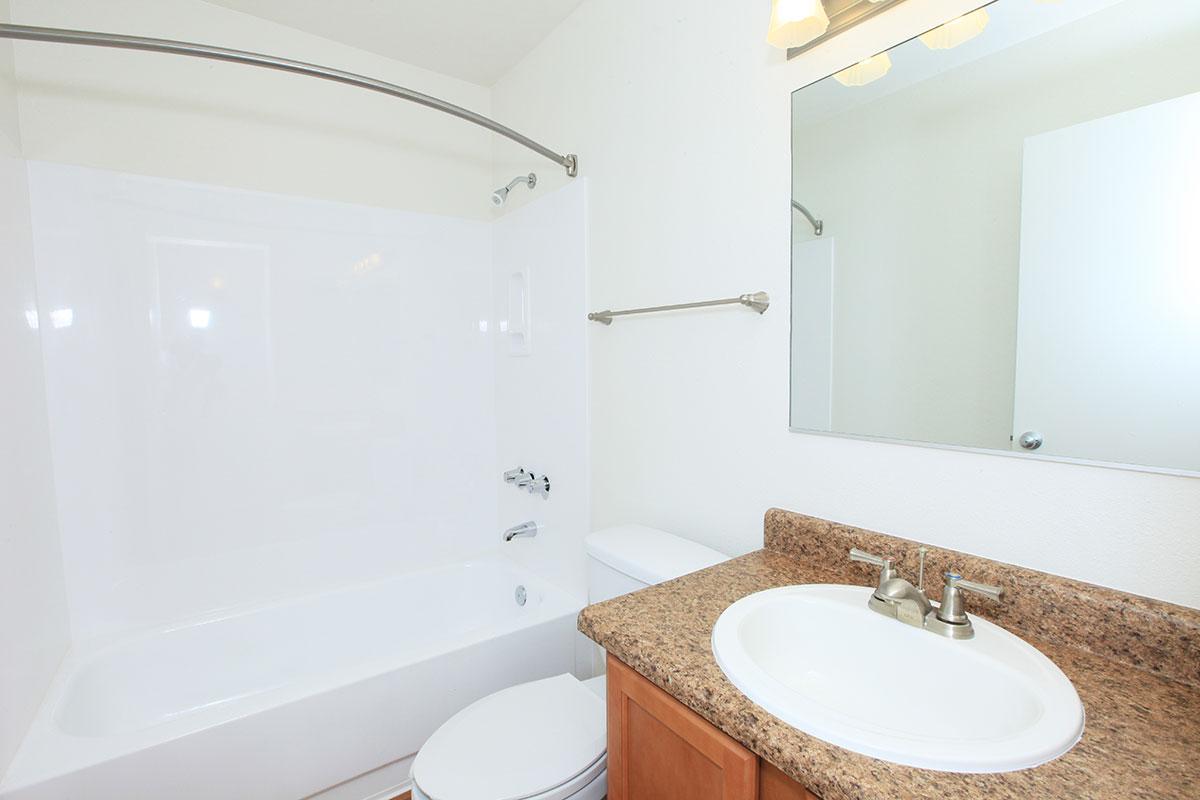 a white sink sitting under a mirror