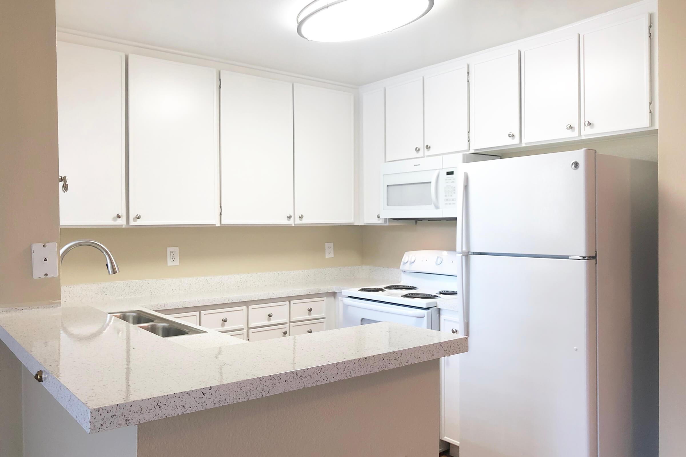 a kitchen with white cabinets and a sink