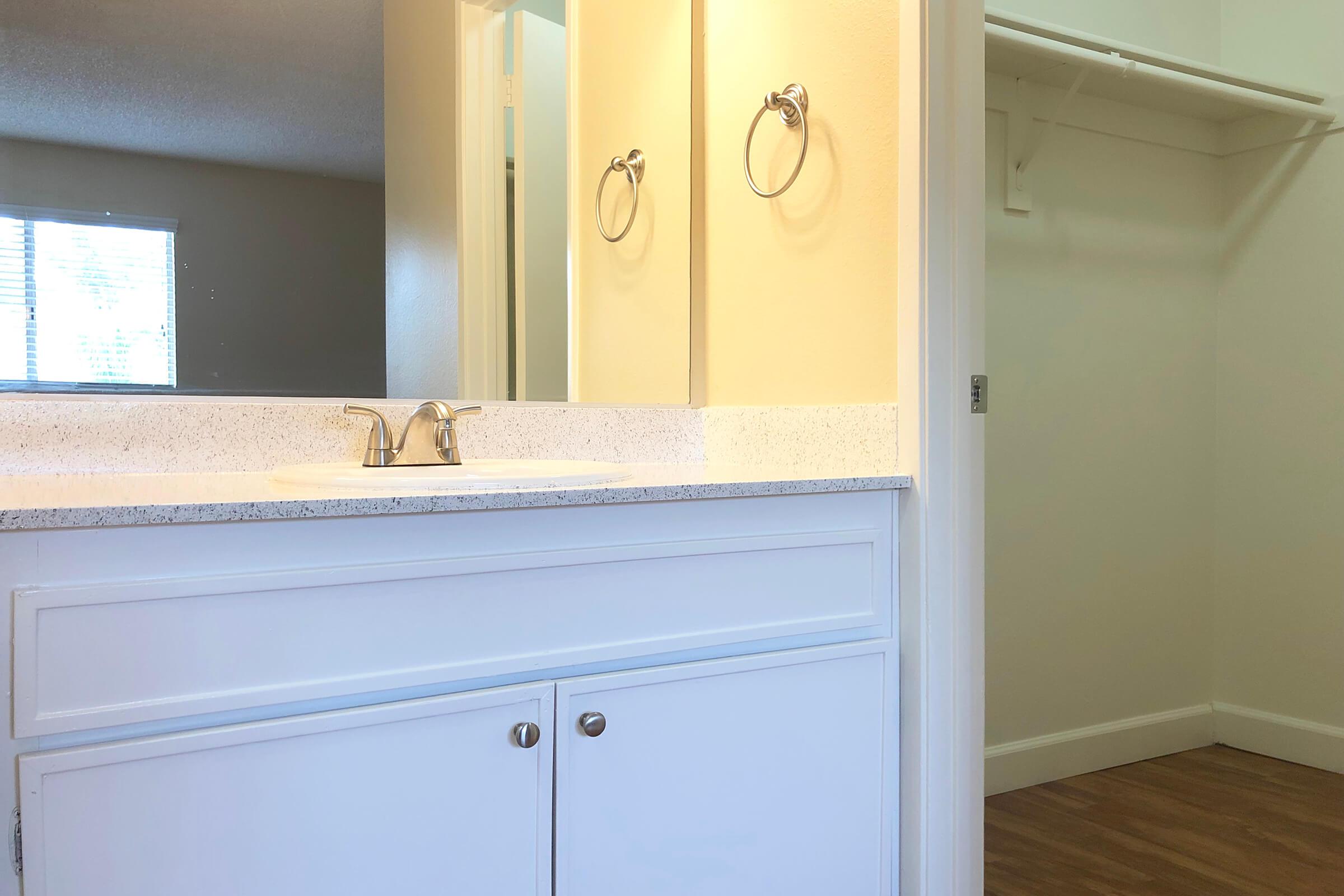 a white sink sitting under a window