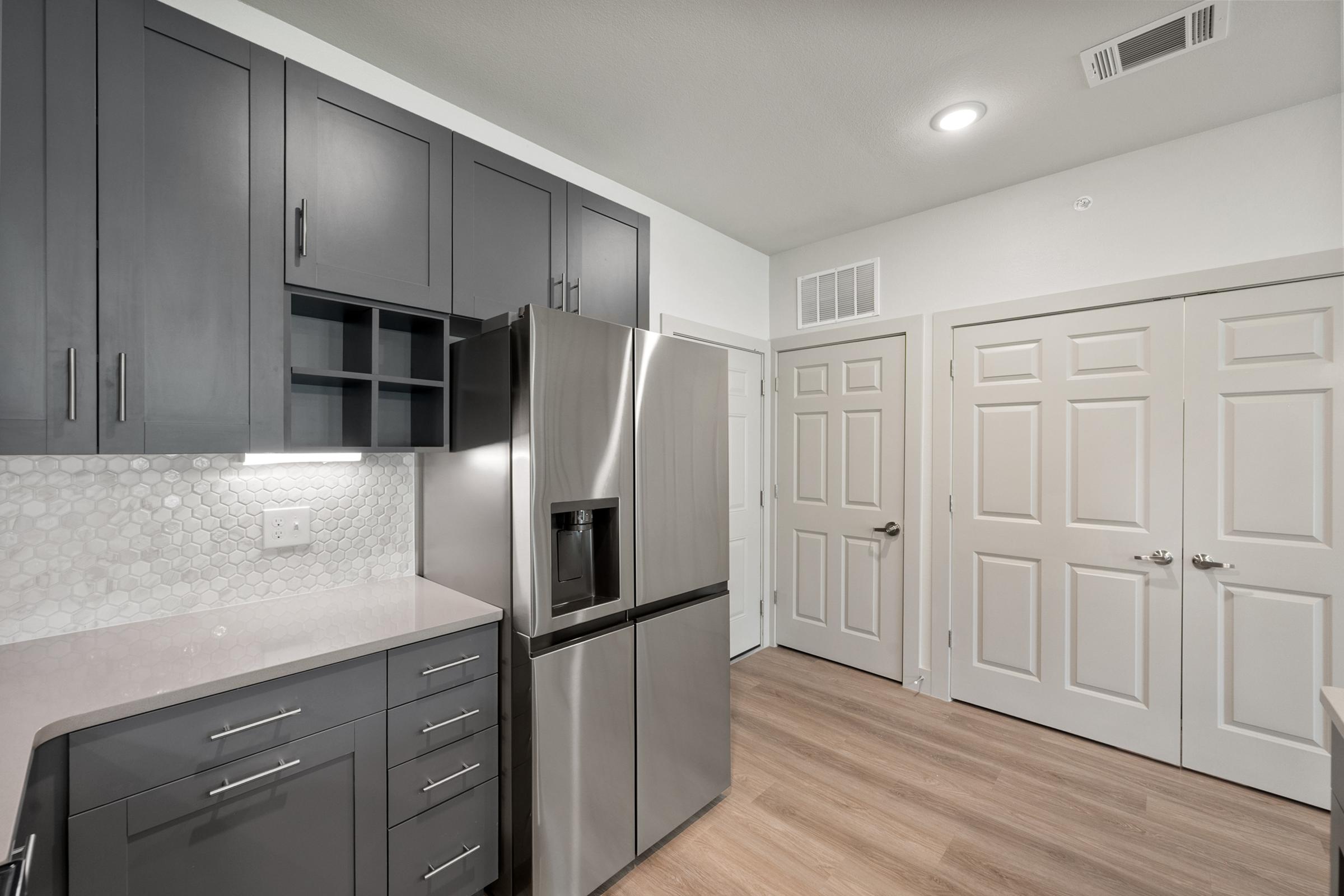 Modern kitchen in the A1 Floor Plan featuring stainless steel appliances, quartz countertops, and sleek cabinetry.