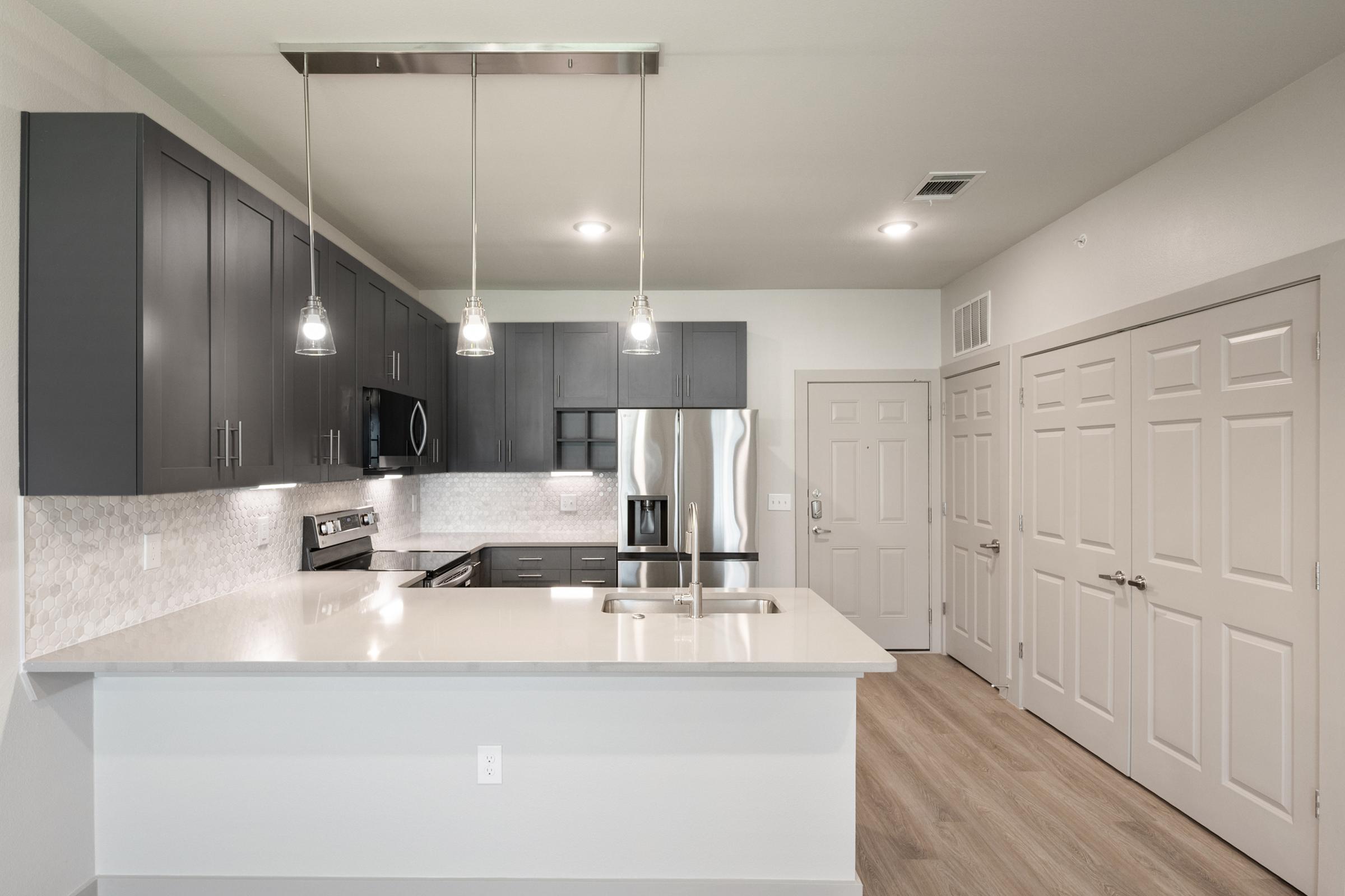 Modern kitchen in the A1 Floor Plan featuring stainless steel appliances, quartz countertops, and sleek cabinetry.