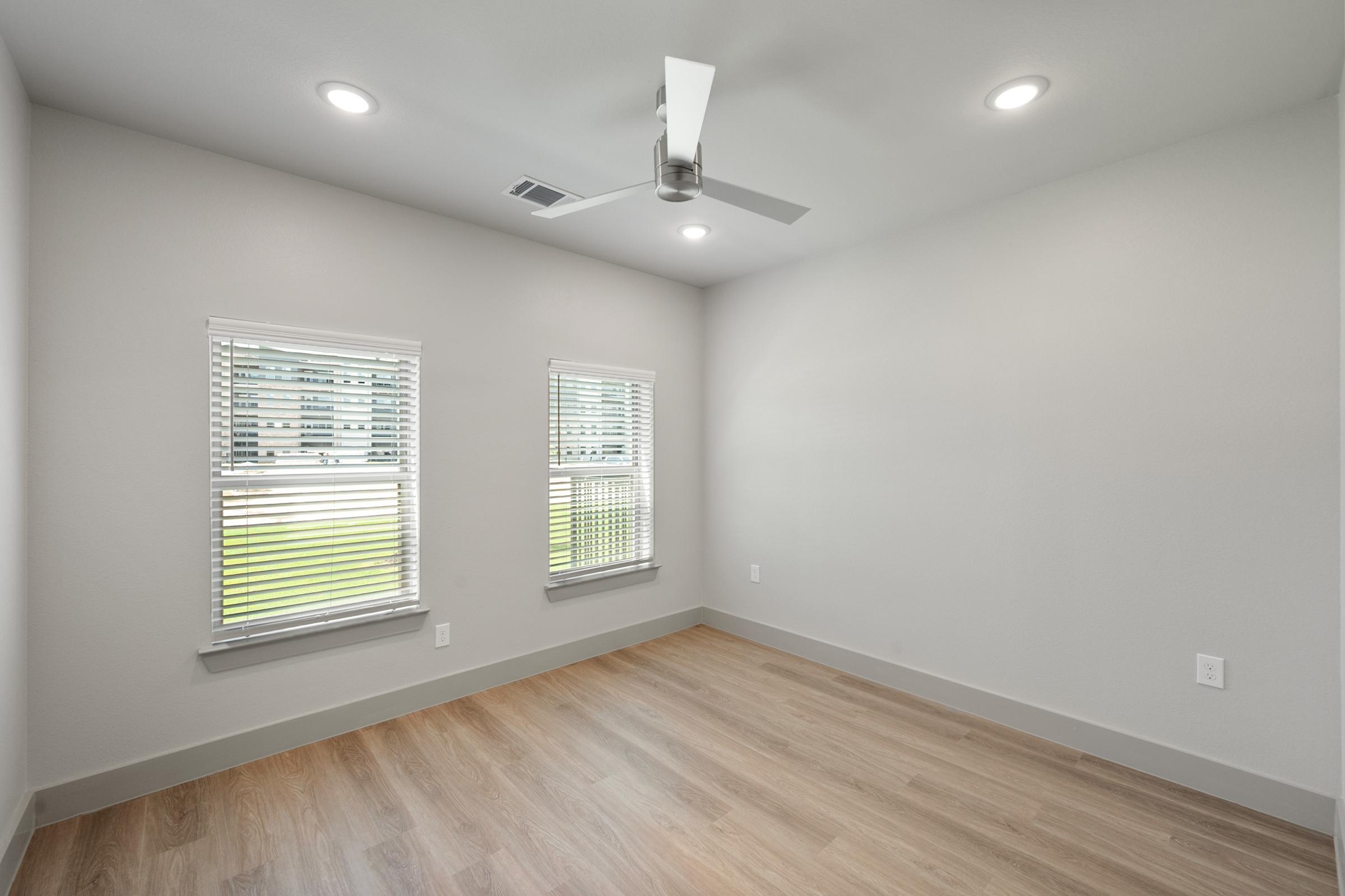 Spacious bedroom in the A2 Floor Plan with plush carpet, natural light, and direct access to a large walk-in closet. *1st floor units feature woodlike flooring.