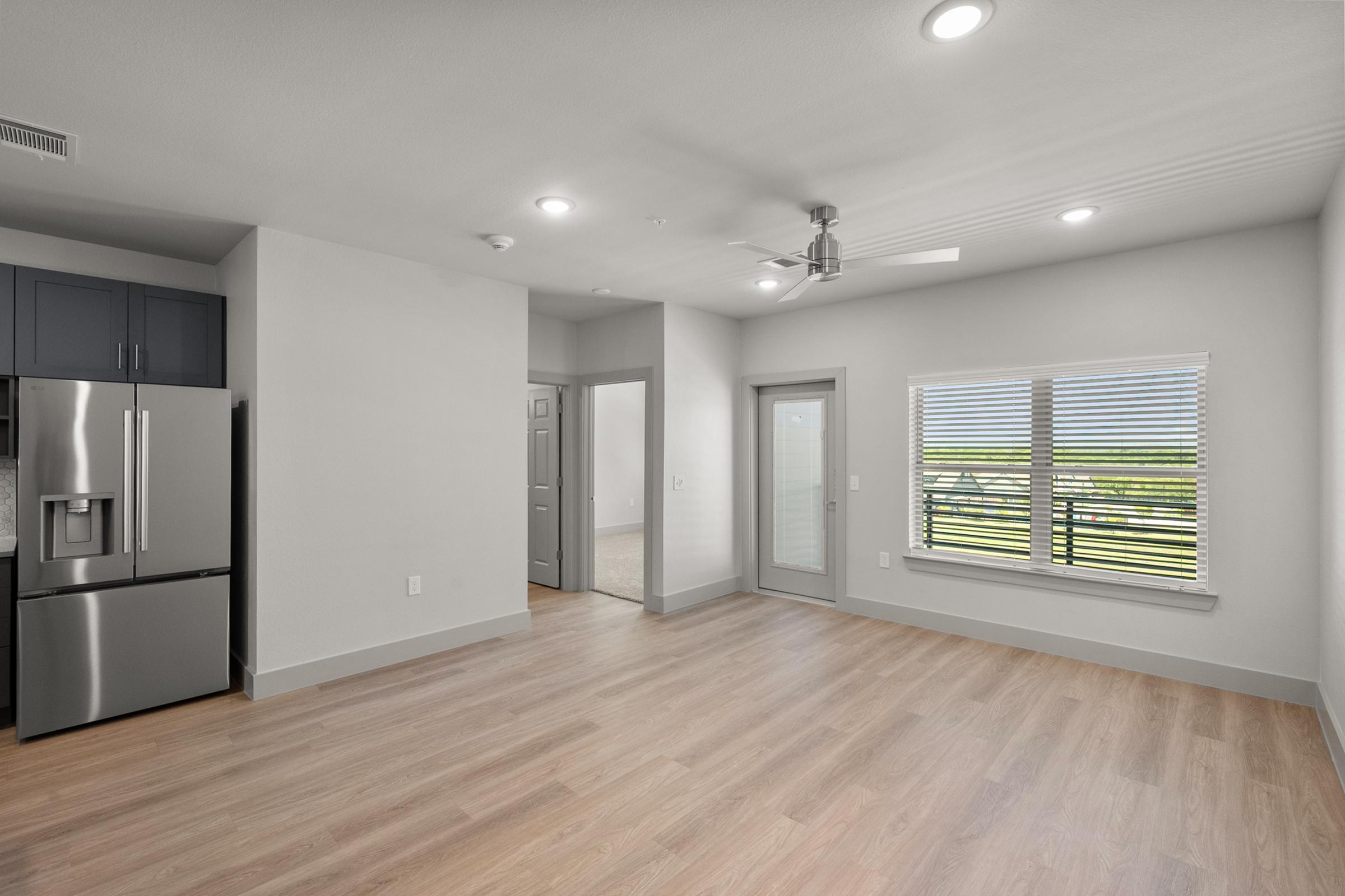 Open-concept living area in the A3 Floor Plan at The Emma Apartments with natural light and spacious layout.