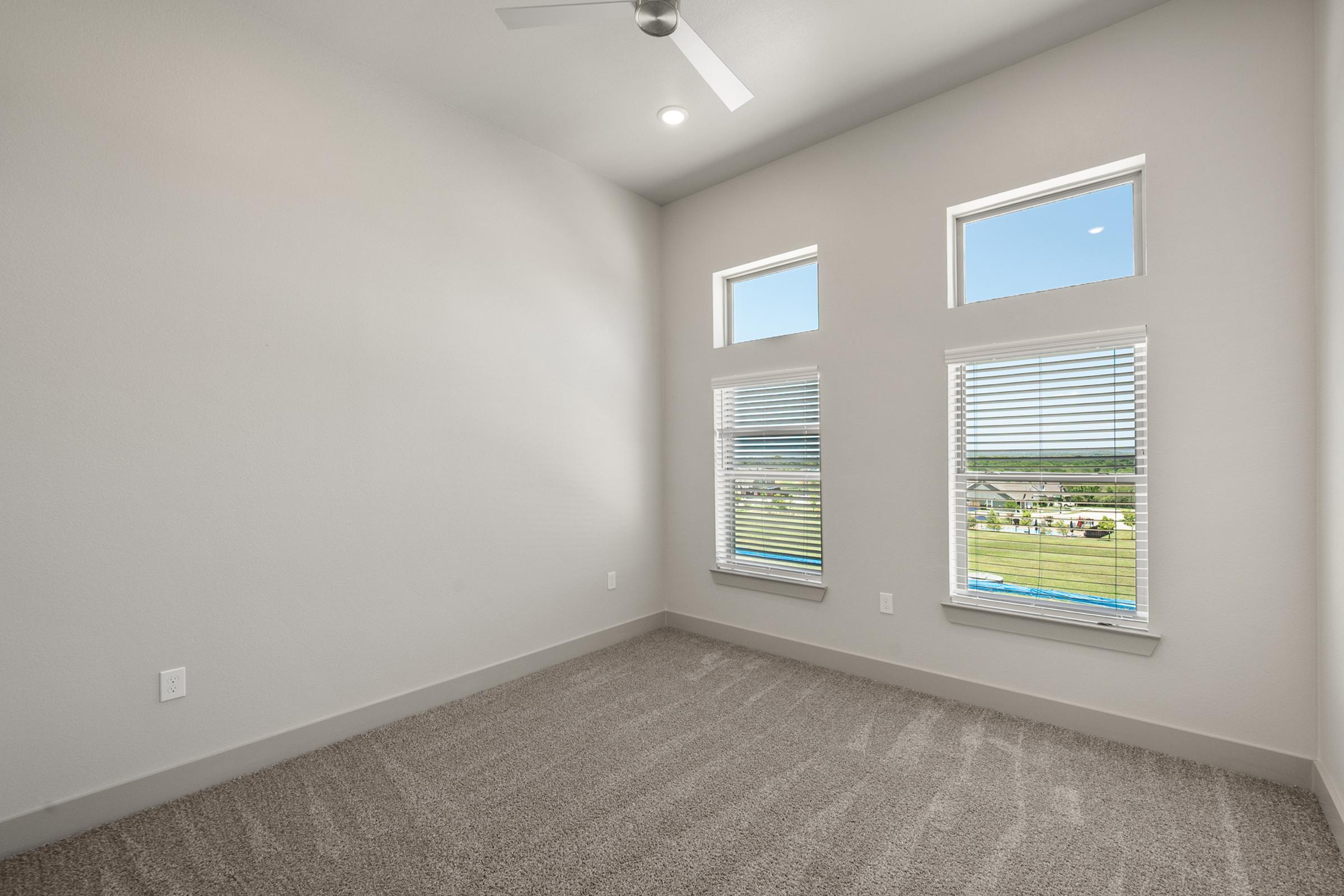 Cozy bedroom with plush carpet and ample natural light in the A3 Floor Plan at The Emma Apartments.