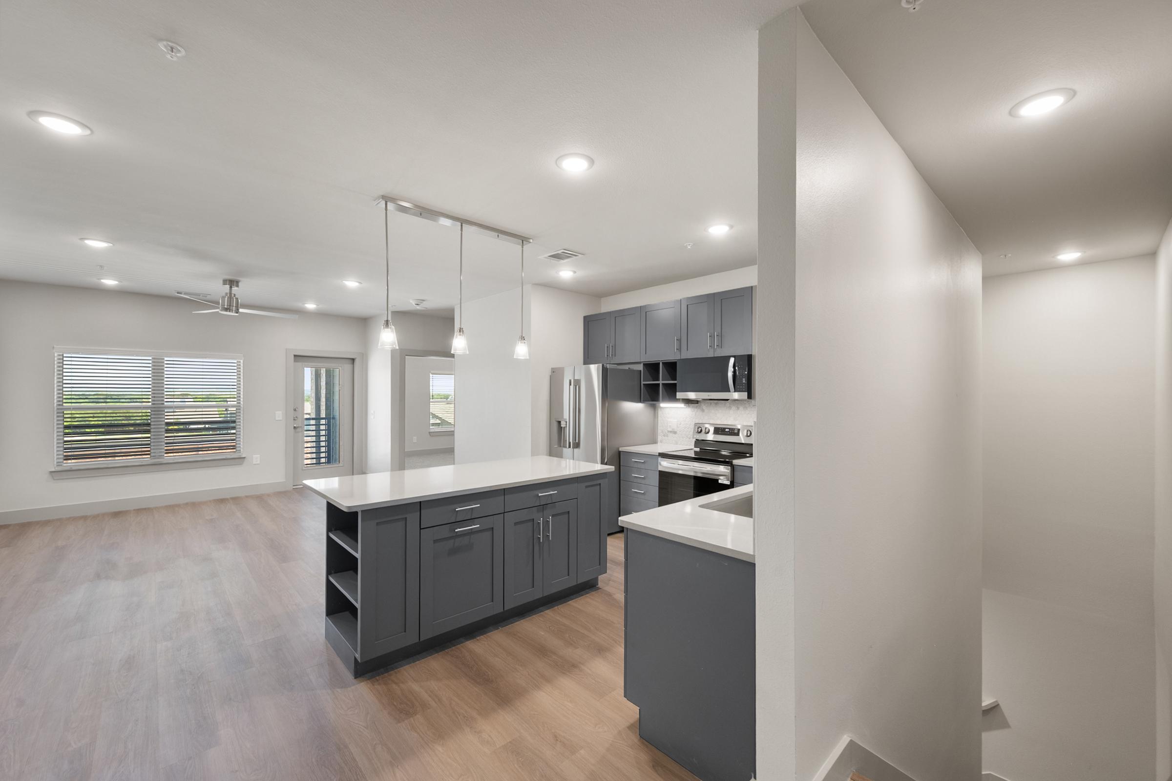 Modern kitchen in the A4 Floor Plan with stainless steel appliances, quartz countertops, and an open layout connected to the living area.