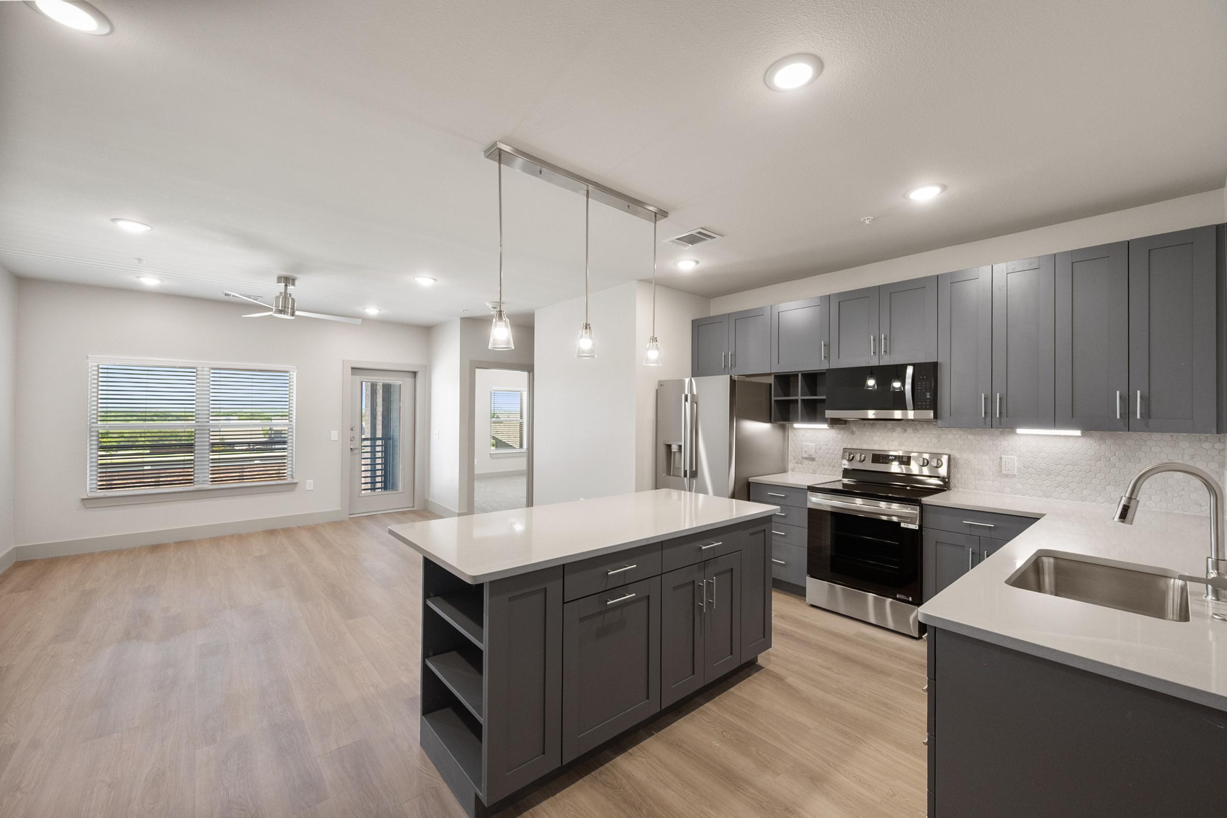 Modern kitchen in the A4 Floor Plan with stainless steel appliances, quartz countertops, and an open layout connected to the living area.