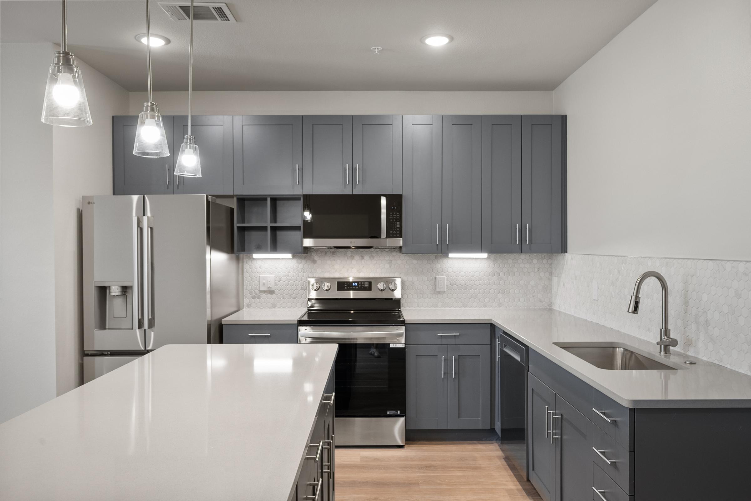 Modern kitchen in the A4 Floor Plan with stainless steel appliances, quartz countertops, and an open layout connected to the living area.
