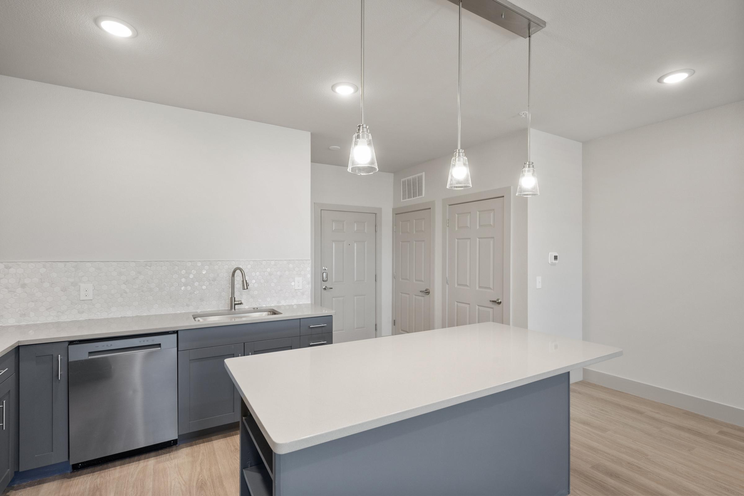 Modern kitchen in the A4 Floor Plan with stainless steel appliances, quartz countertops, and an open layout connected to the living area.
