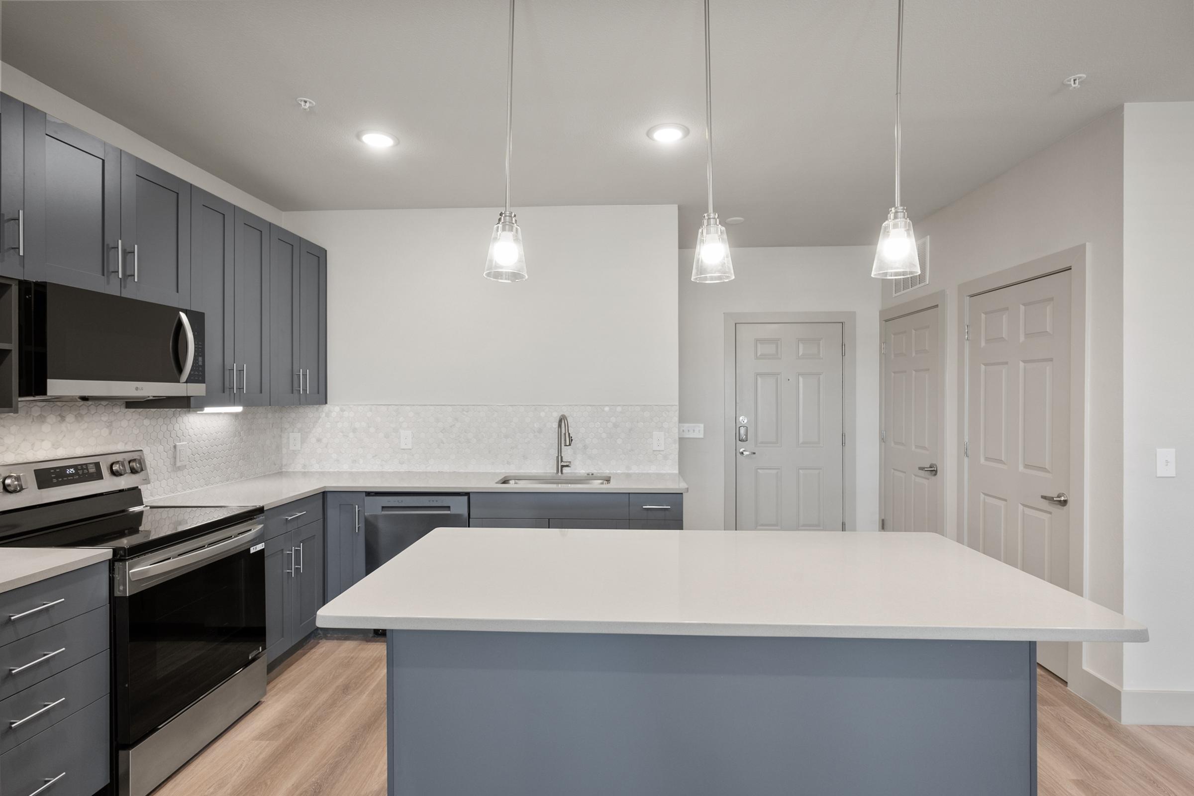 Modern kitchen in the A4 Floor Plan with stainless steel appliances, quartz countertops, and an open layout connected to the living area.