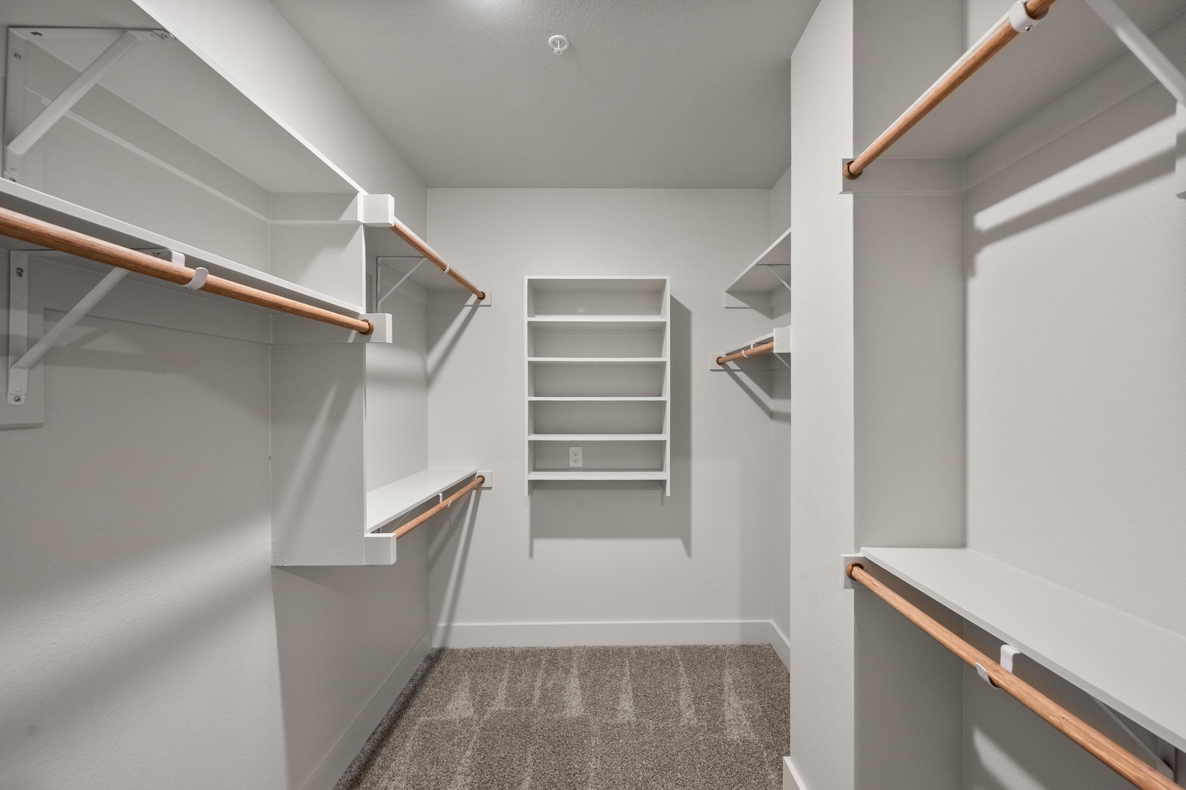 pacious walk-in closet in the A4 Floor Plan at The Emma Apartments with built-in shelving and ample hanging space for organized storage.