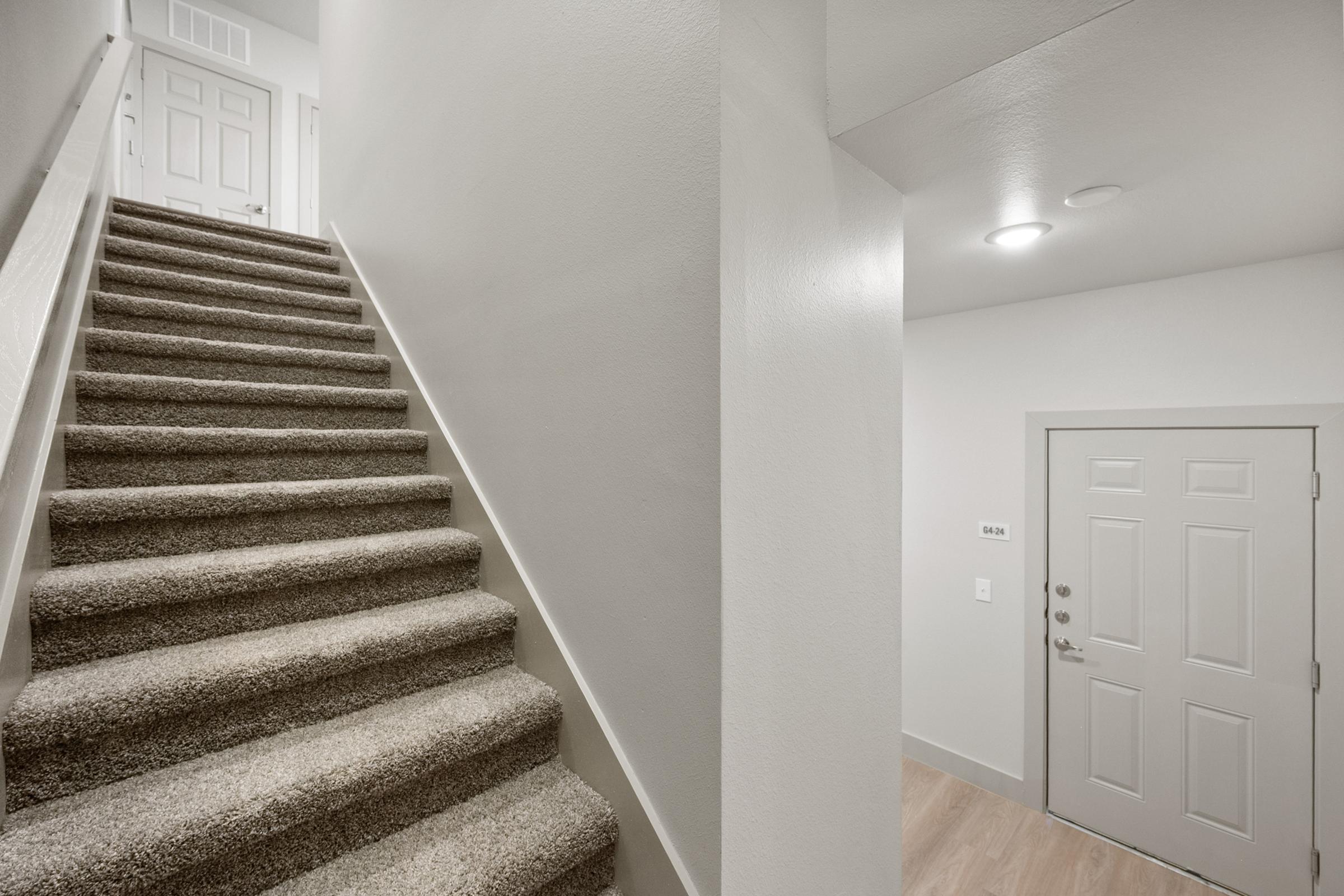 Interior private staircase leading from the garage level to the main living area in the A4 townhome-style unit.