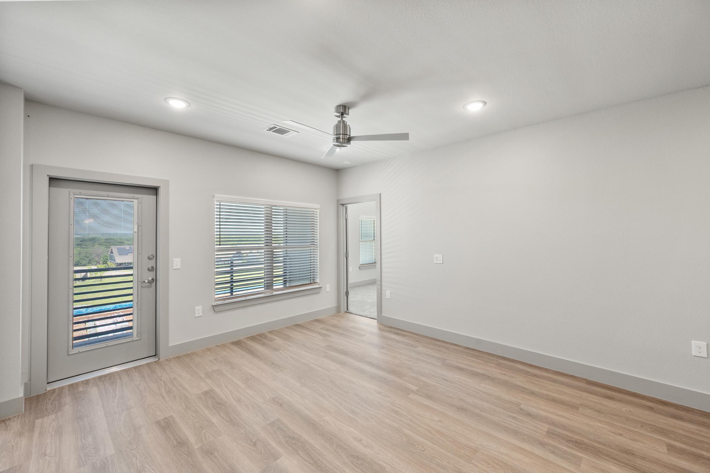 Open-concept living room with high ceilings, large windows, and direct access to the kitchen and dining spaces for easy entertaining.