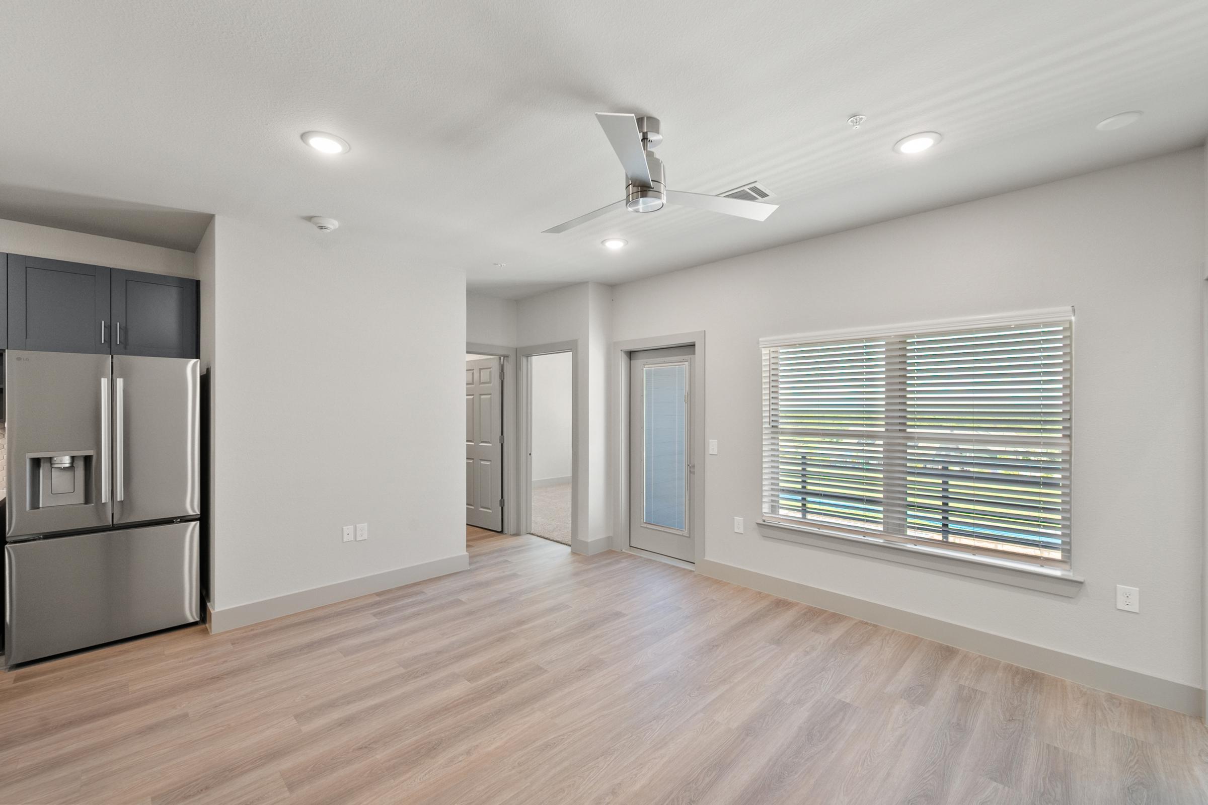 Open-concept living room with high ceilings, large windows, and direct access to the kitchen and dining spaces for easy entertaining.