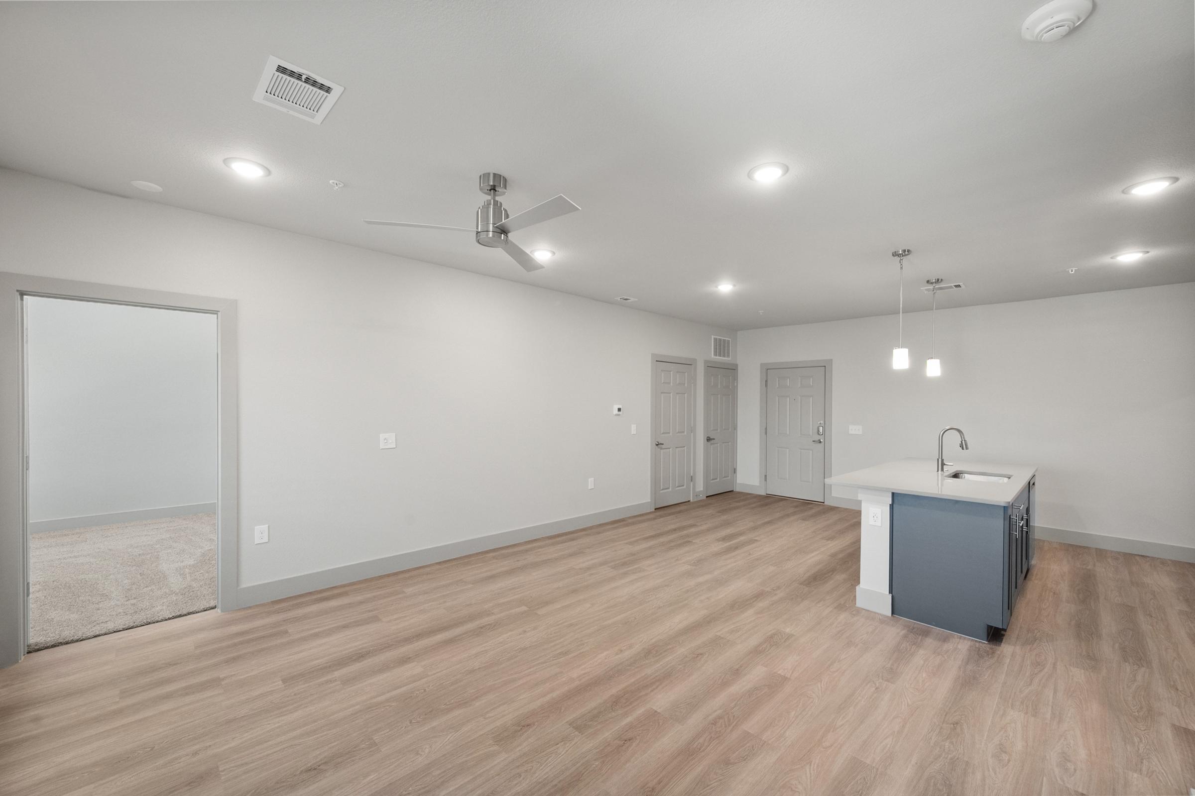 Open-concept living room with high ceilings, large windows, and direct access to the kitchen and dining spaces for easy entertaining.