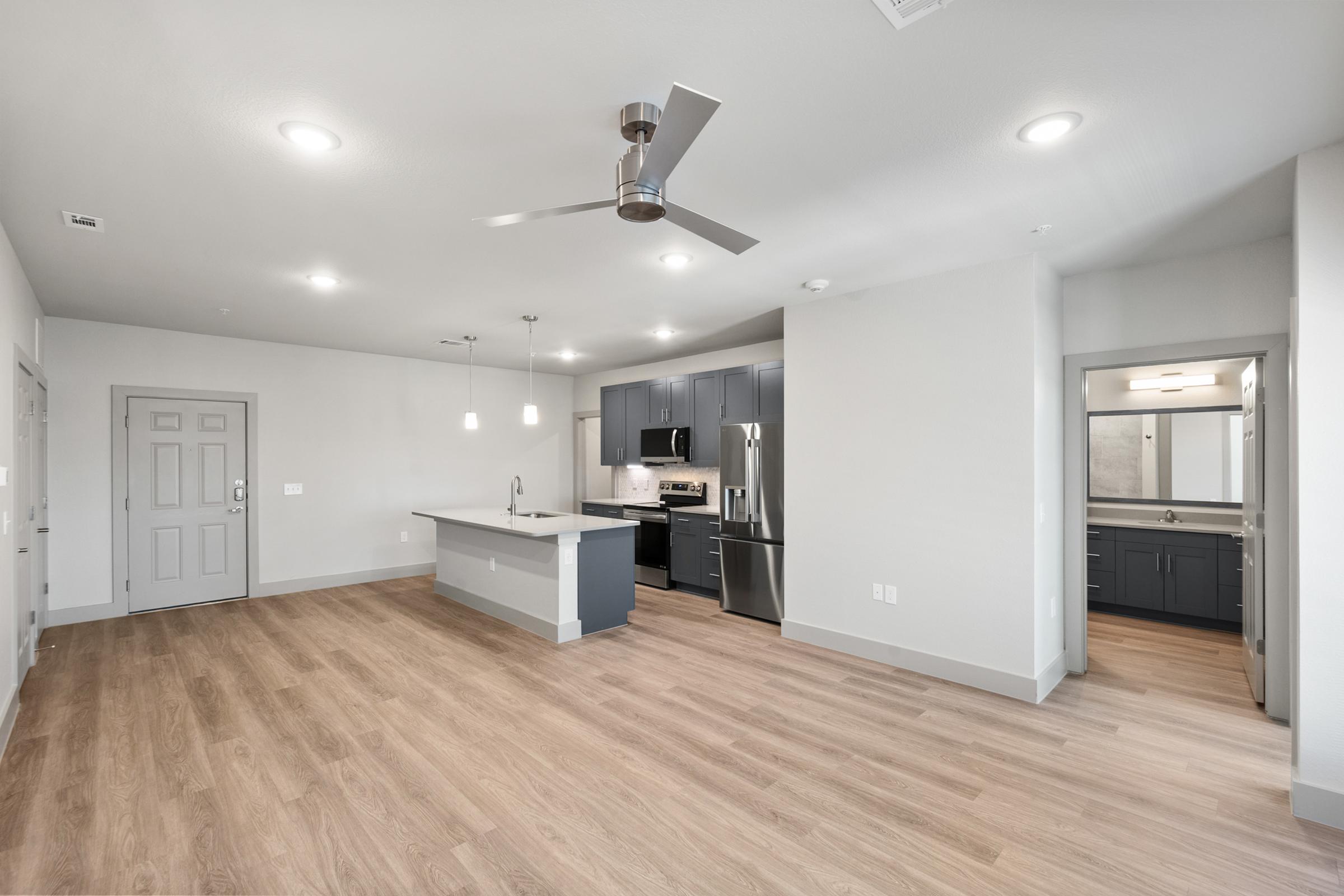 Open-concept living room with high ceilings, large windows, and direct access to the kitchen and dining spaces for easy entertaining.