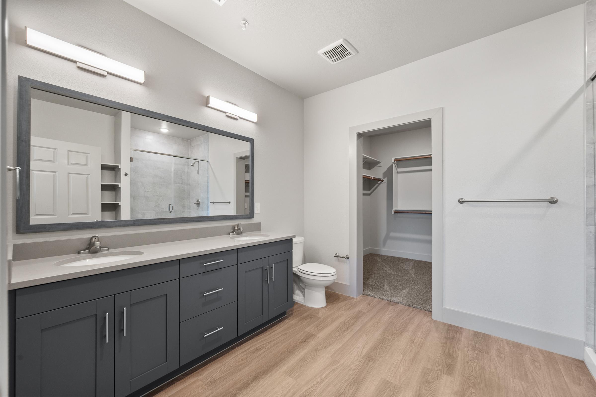 Primary bathroom with dual vanities, modern fixtures, and a clean, bright design for a spa-like feel.