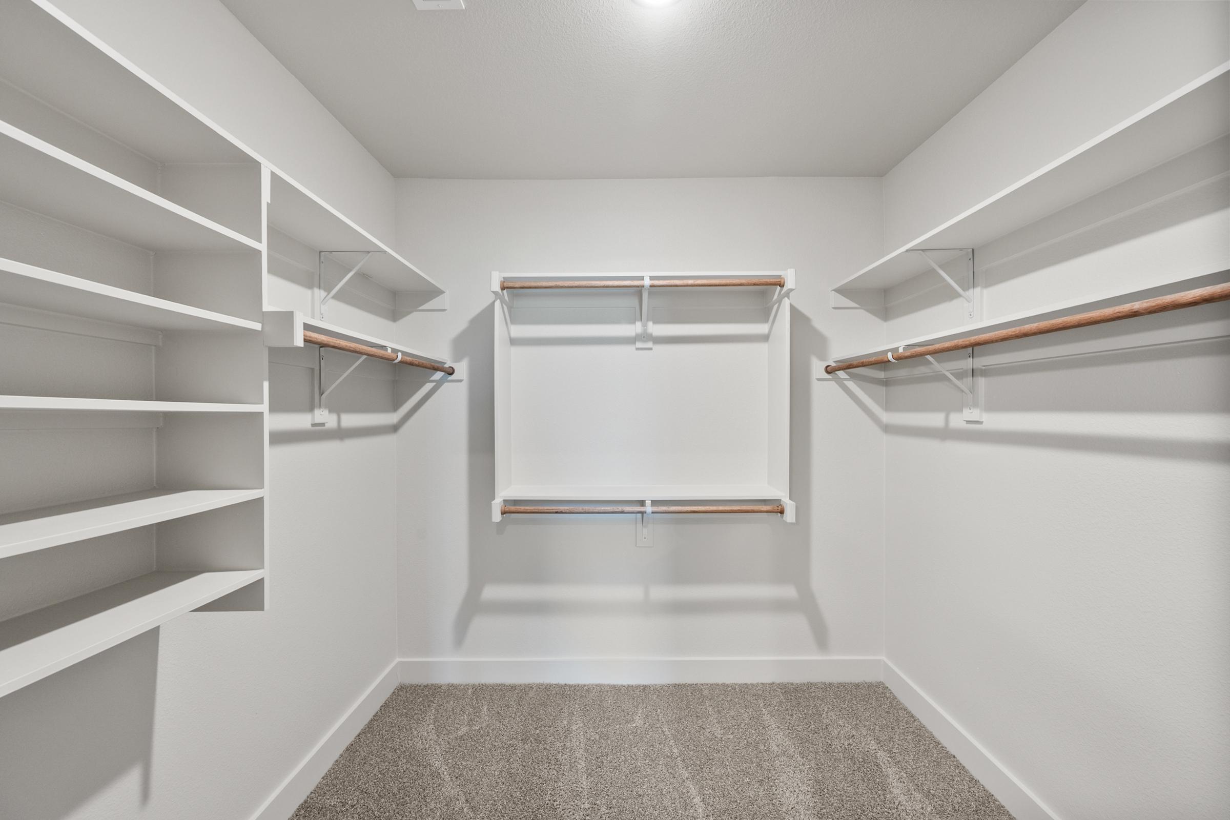 Generous walk-in closet in the primary suite offering ample storage with built-in shelving and hanging space.