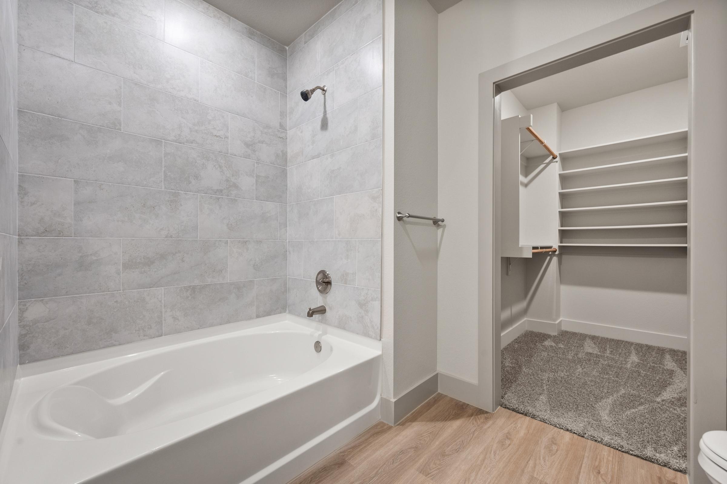 Secondary bathroom in the B1 Floor Plan at The Emma Apartments featuring a tub-shower combo, sleek fixtures, and a modern, clean design.