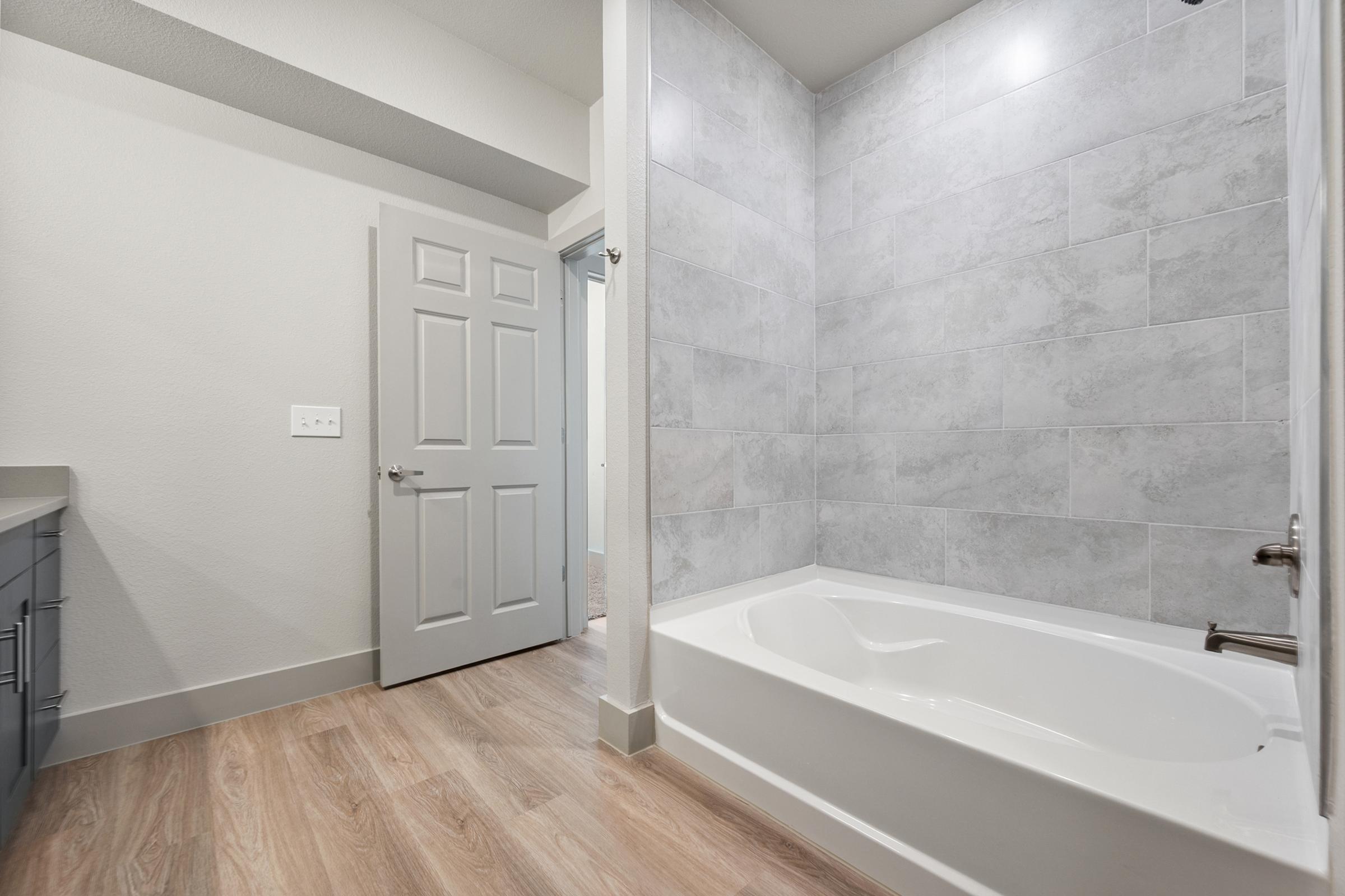 Secondary bathroom in the B1 Floor Plan at The Emma Apartments featuring a tub-shower combo, sleek fixtures, and a modern, clean design.