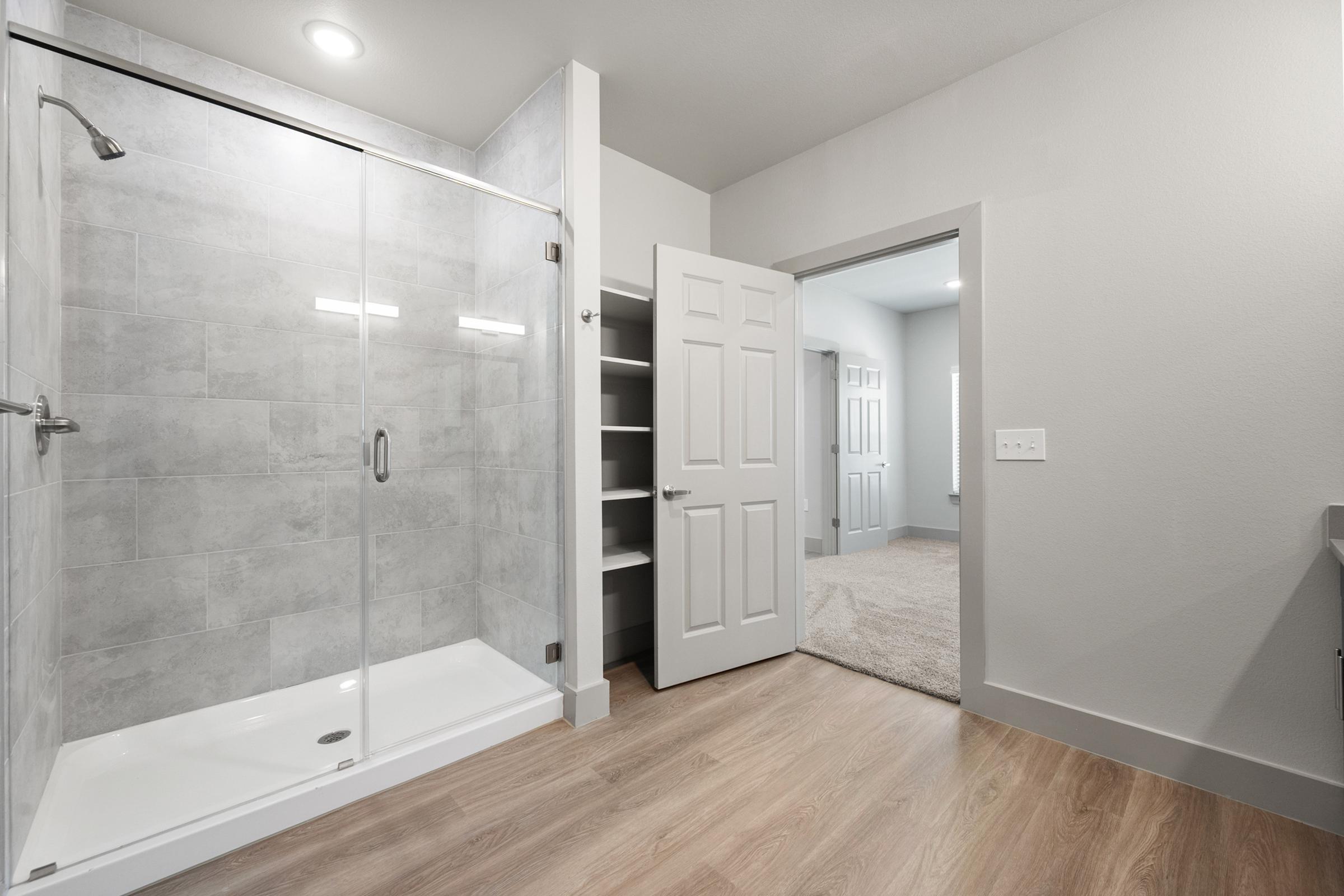 Ensuite primary bathroom with dual vanities, sleek fixtures, and a spacious walk-in shower for a spa-like experience.