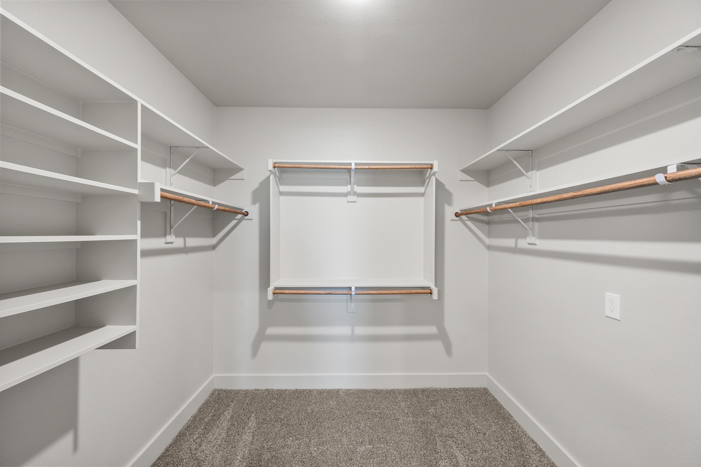 Large walk-in closet in the B2 primary suite with built-in shelving and ample hanging space.