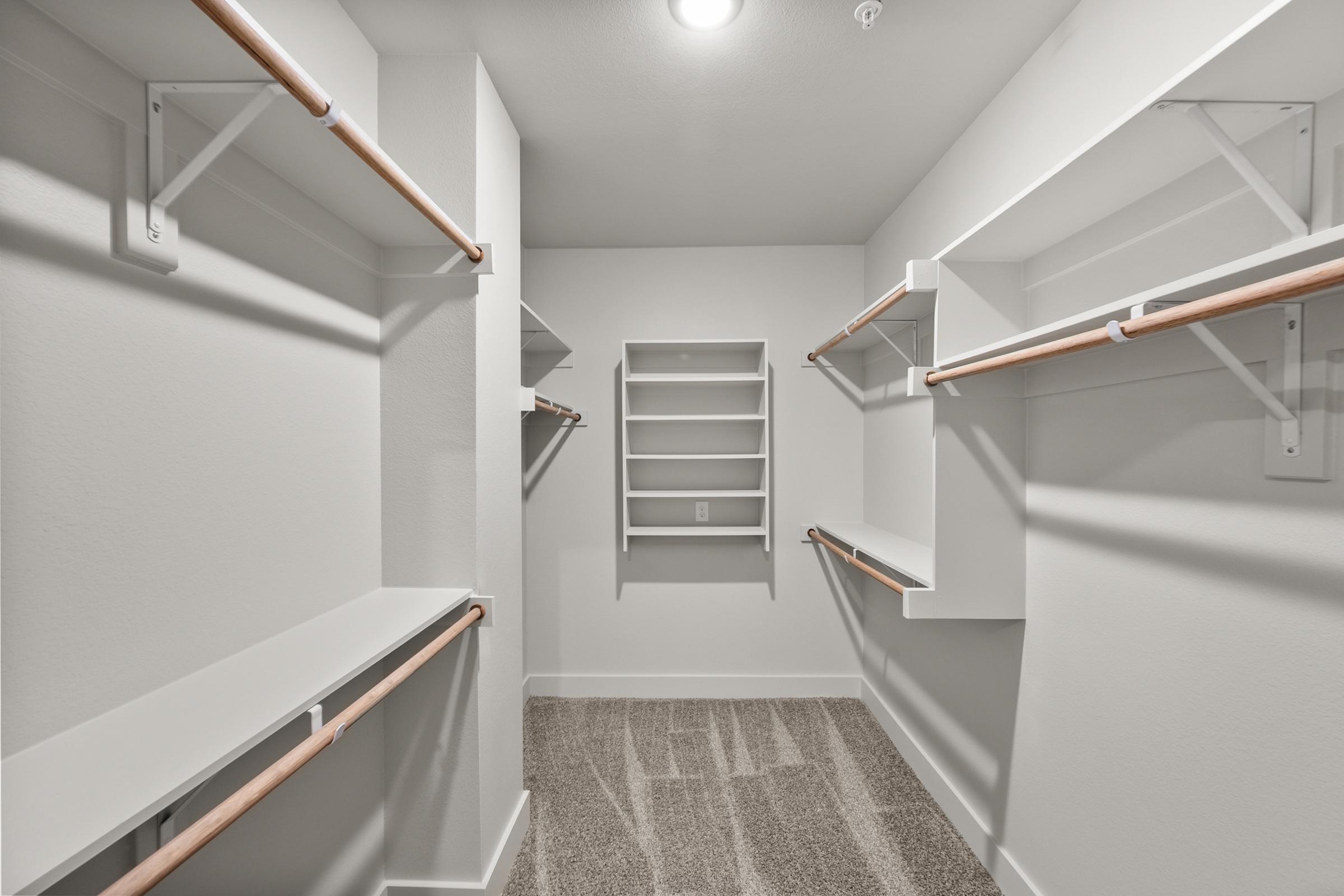 Secondary bedroom closet in the B2 Floor Plan at The Emma Apartments offering ample storage with hanging space and built-in shelving.