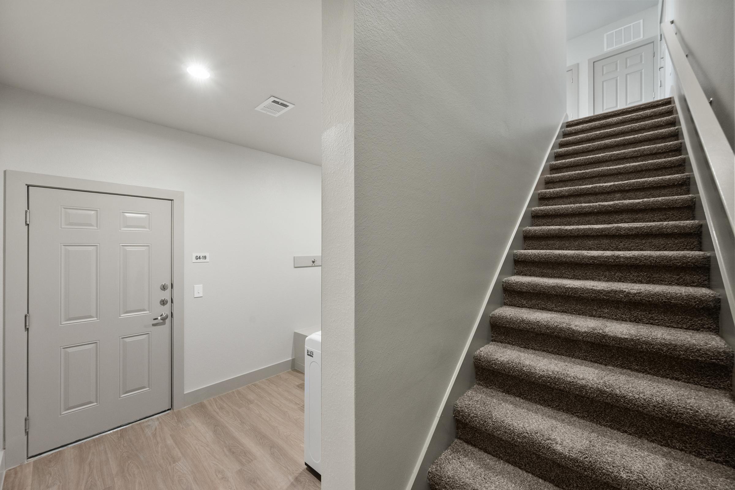 Attached private garage with interior stairs providing direct access to the main living space in the B2 townhome-style unit.