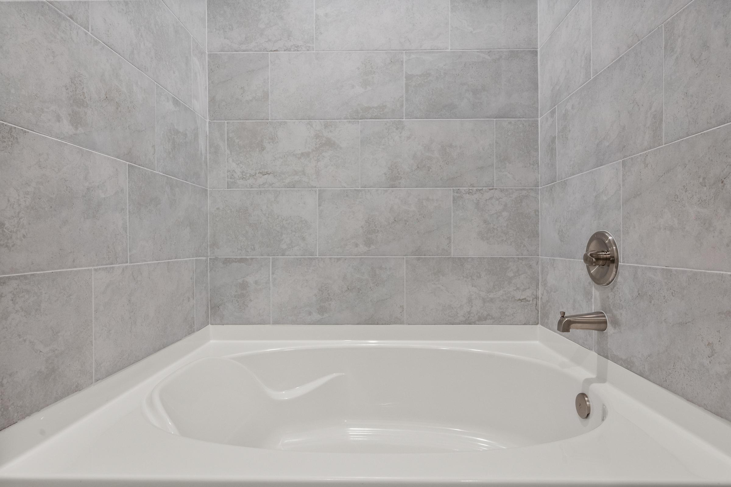 Secondary bathroom in the C1 unit featuring a tub-shower combination, modern vanity, and clean, contemporary design.