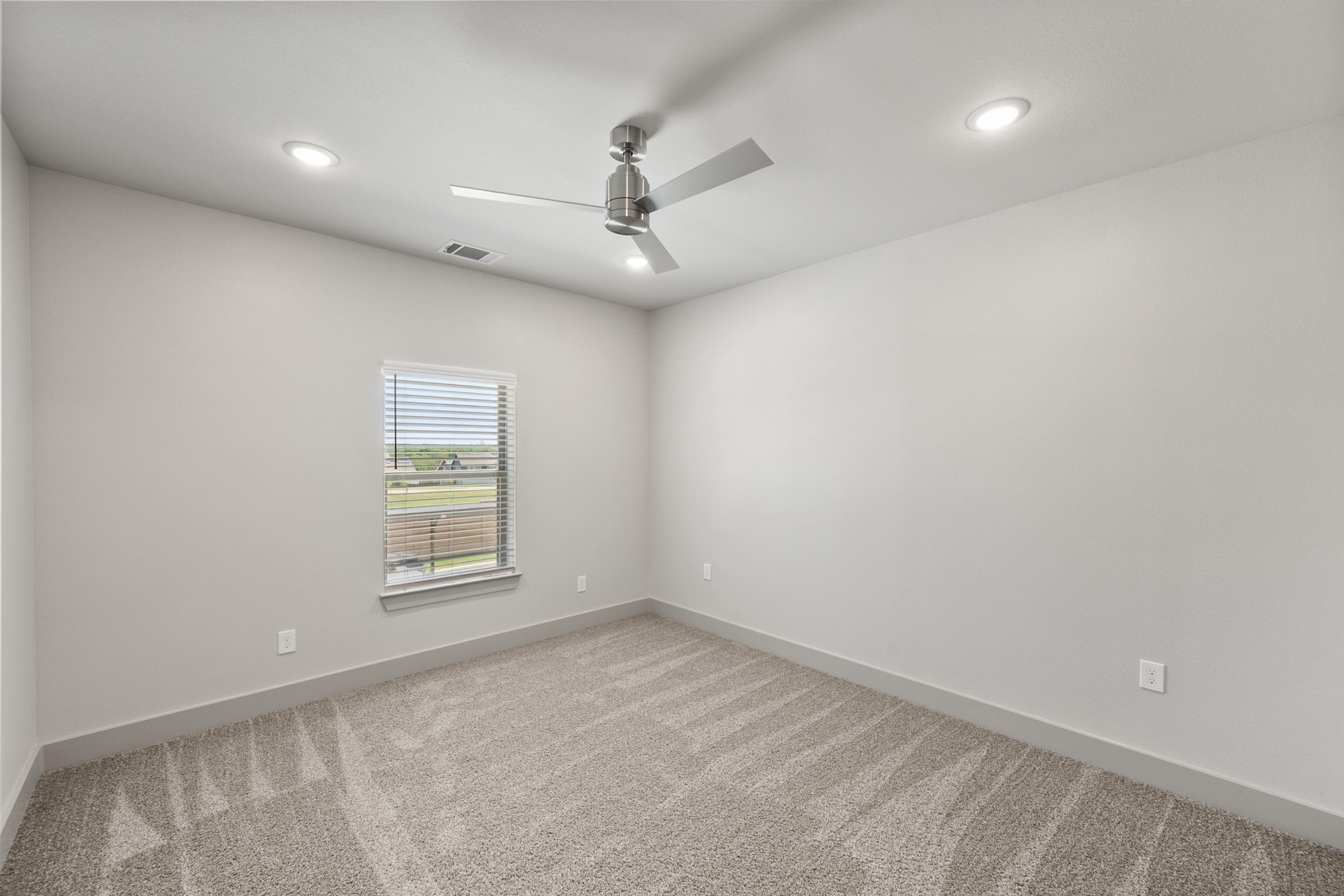 Versatile third bedroom perfect for guests, a home office, or nursery, complete with a large window and spacious closet.