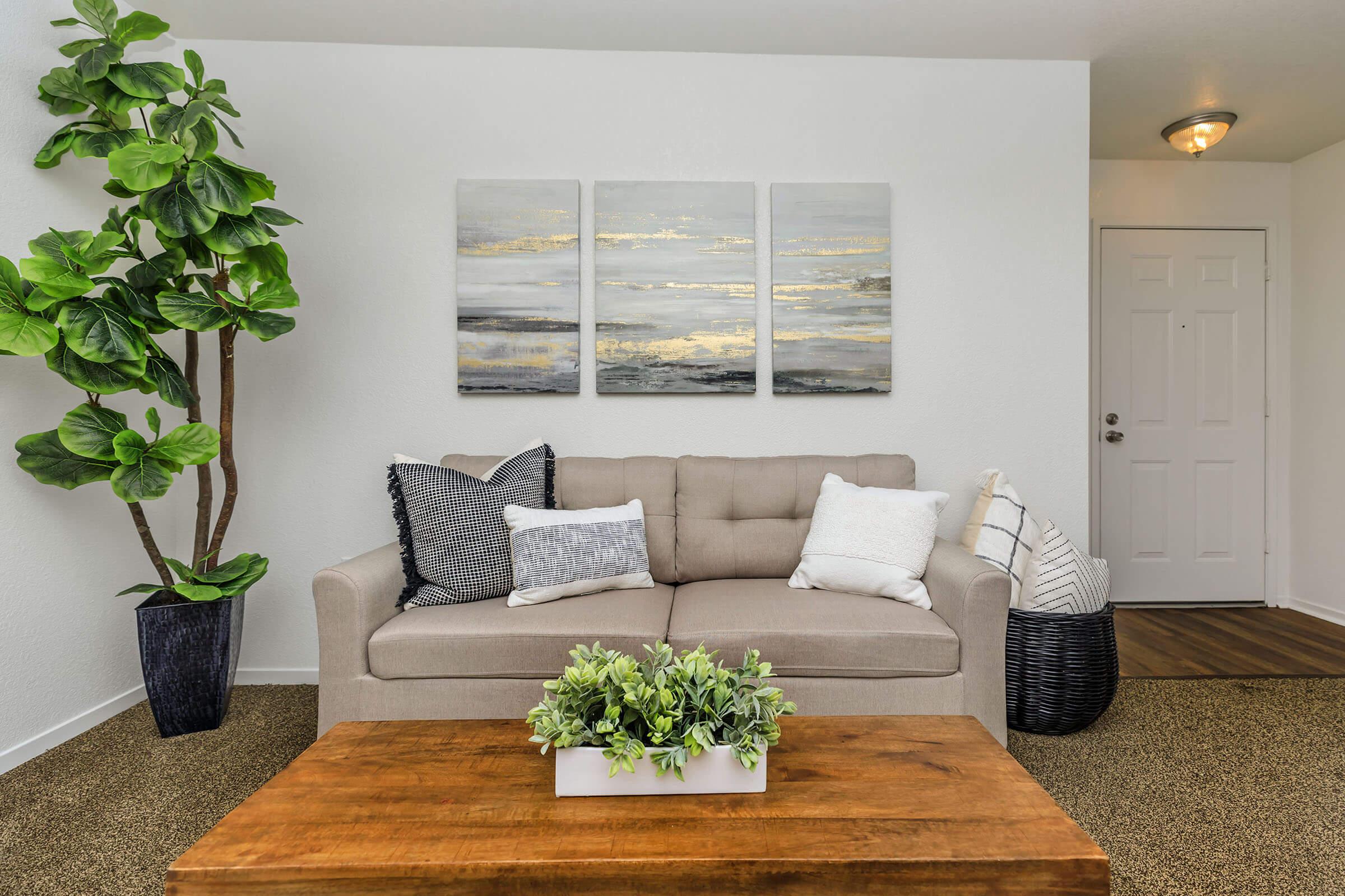 a living room filled with furniture and vase of flowers on a table