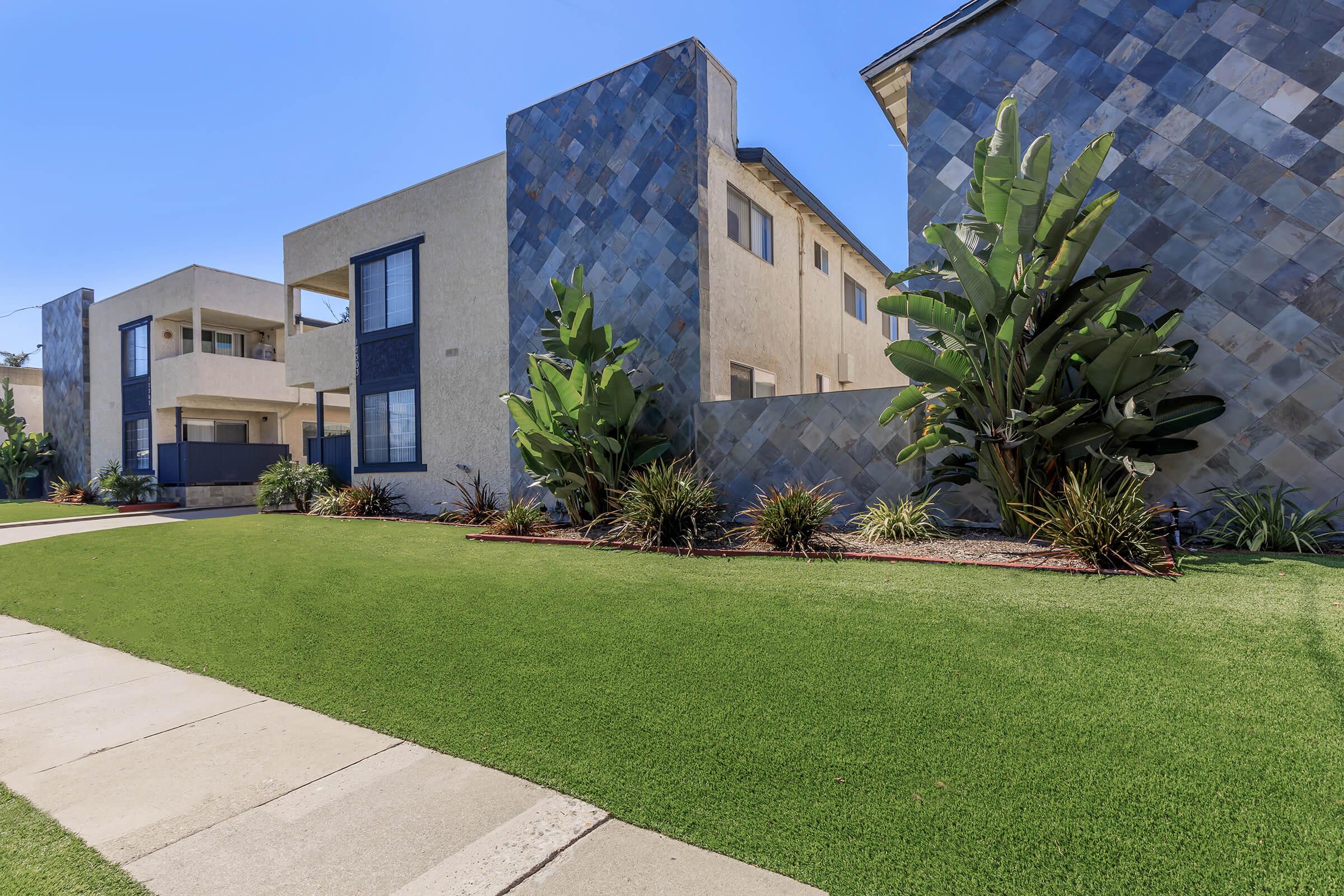 a large brick building with green grass