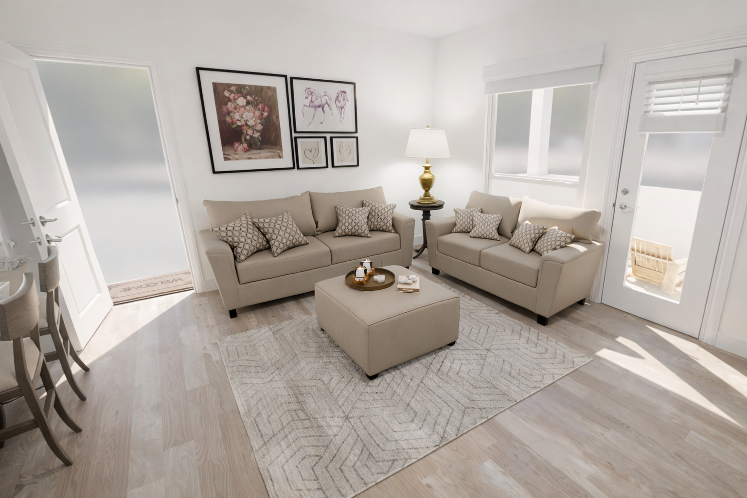 A modern living room featuring light beige sofas adorned with patterned cushions, an ottoman coffee table in the center, and a decorative vase. There are framed artworks on the wall, a lamp beside the sofa, and large windows allowing natural light. Light wooden flooring enhances the airy ambiance.